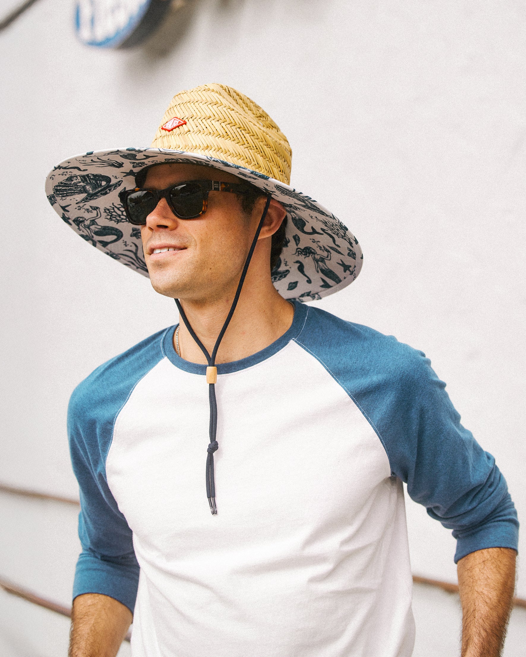 Hemlock male model wearing the UPF50+ Lifeguard Straw Hat Mermaid print up close