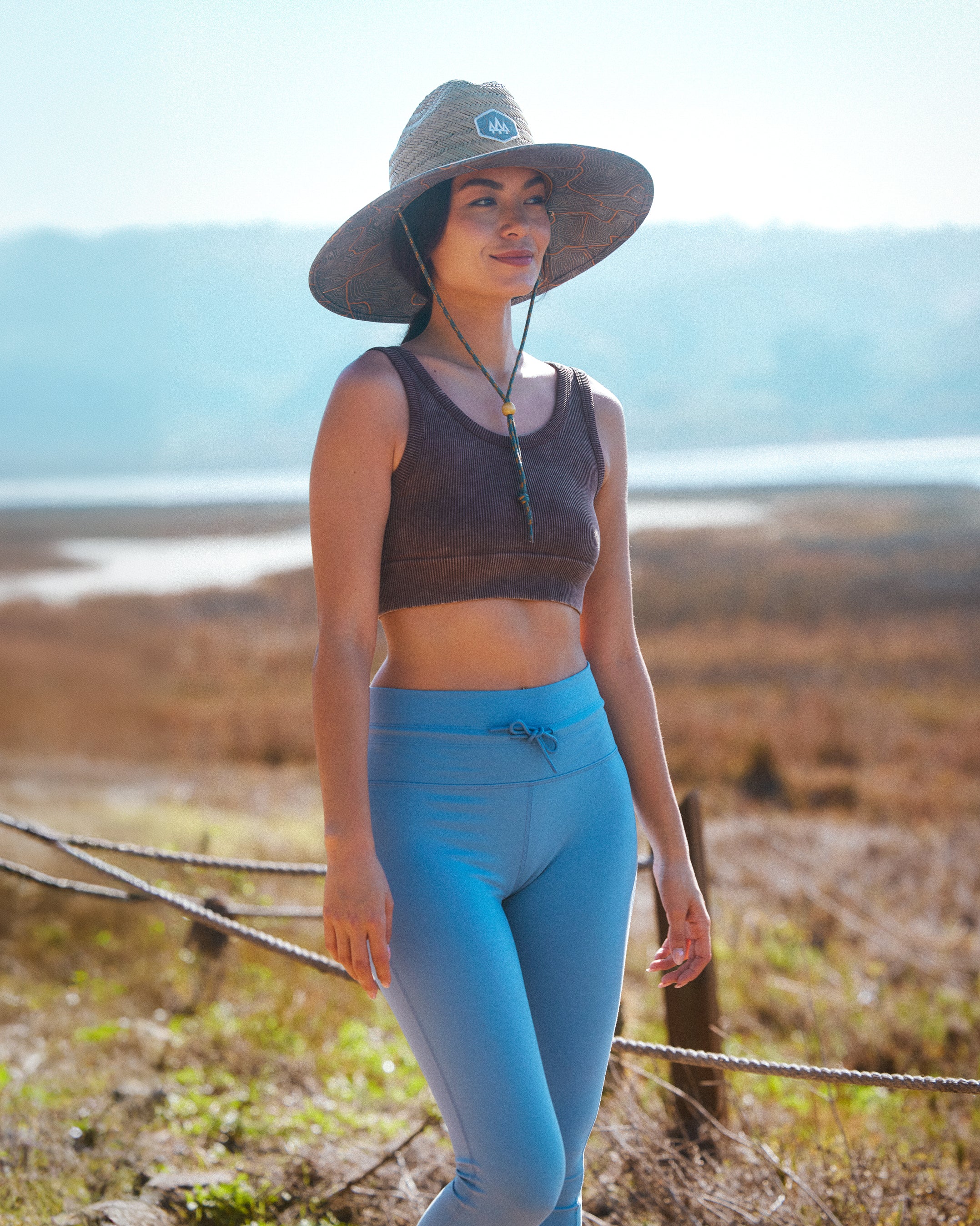 Hemlock female model wearing the UPF50+ Lifeguard Straw Hat Nomad Topography print