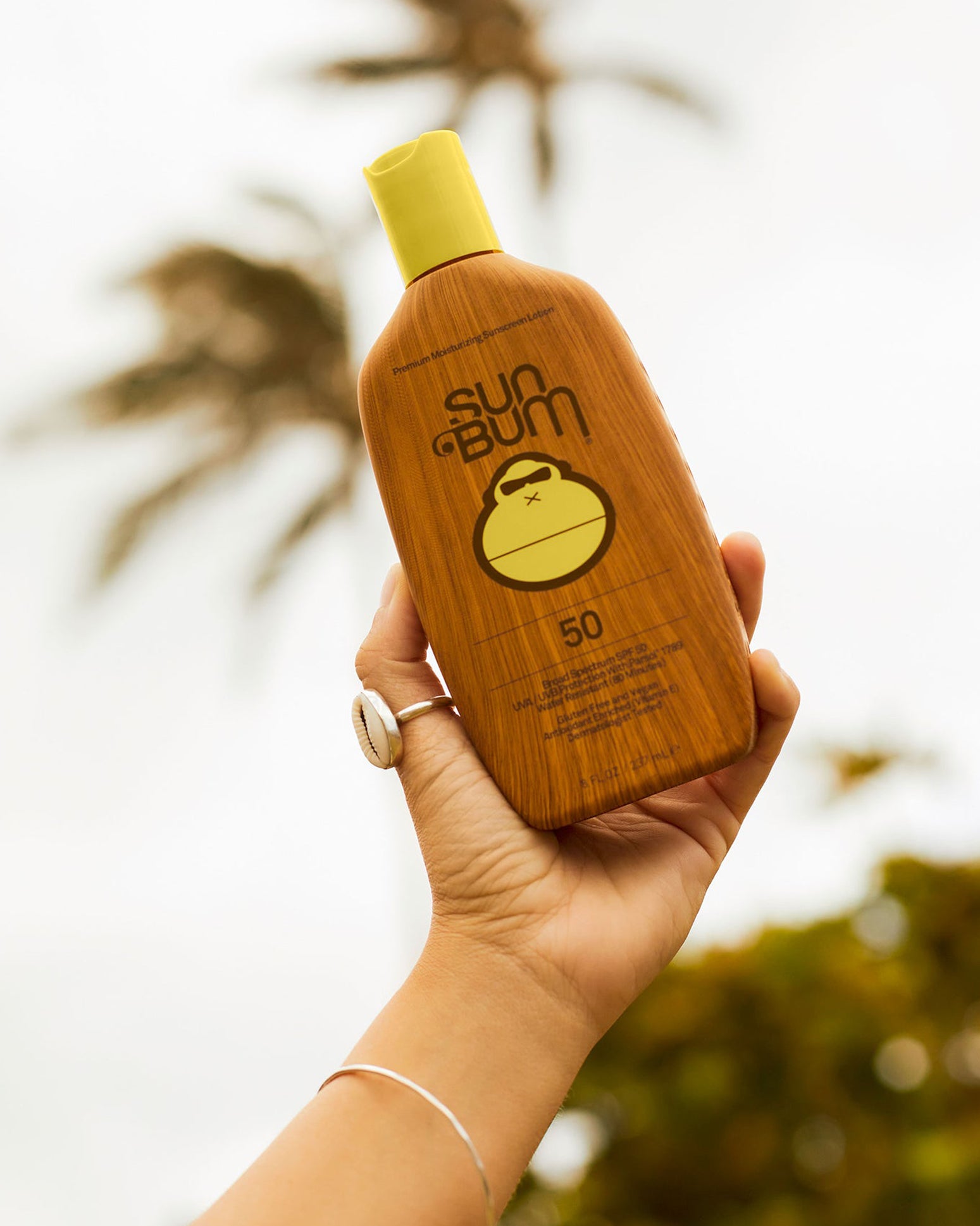 Sun Bum Original SPF 50 sunscreen lotion product image front view held in a person's hand.