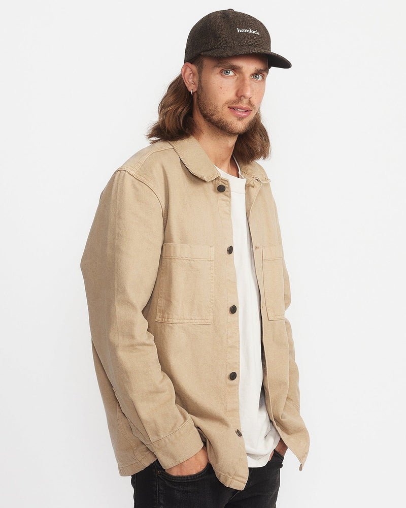 Hemlock male model looking over his shoulder wearing Bristol Dad Hat in Brown and Black