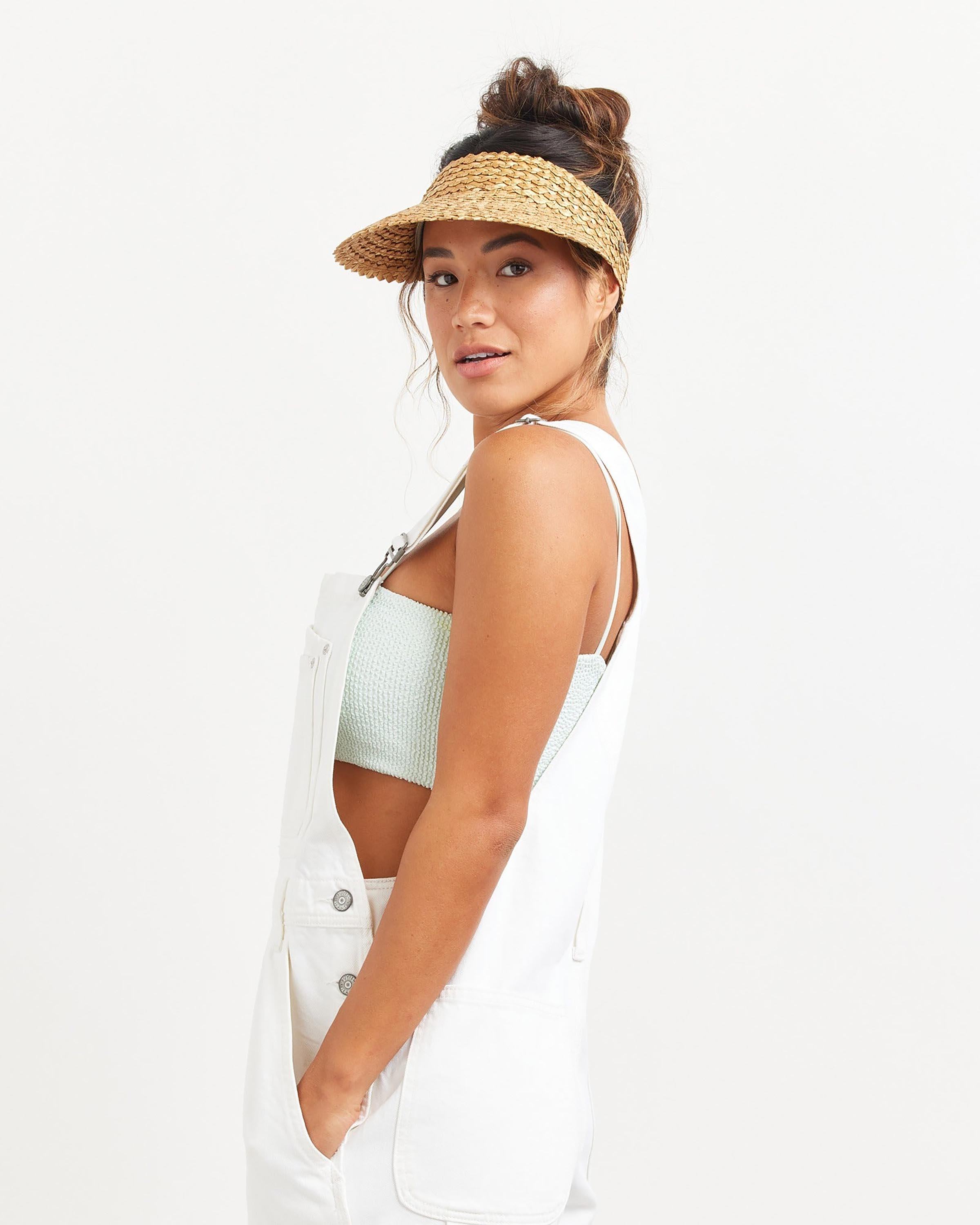 Hemlock female model looking over her shoulder wearing Capri Straw visor in Honeycomb