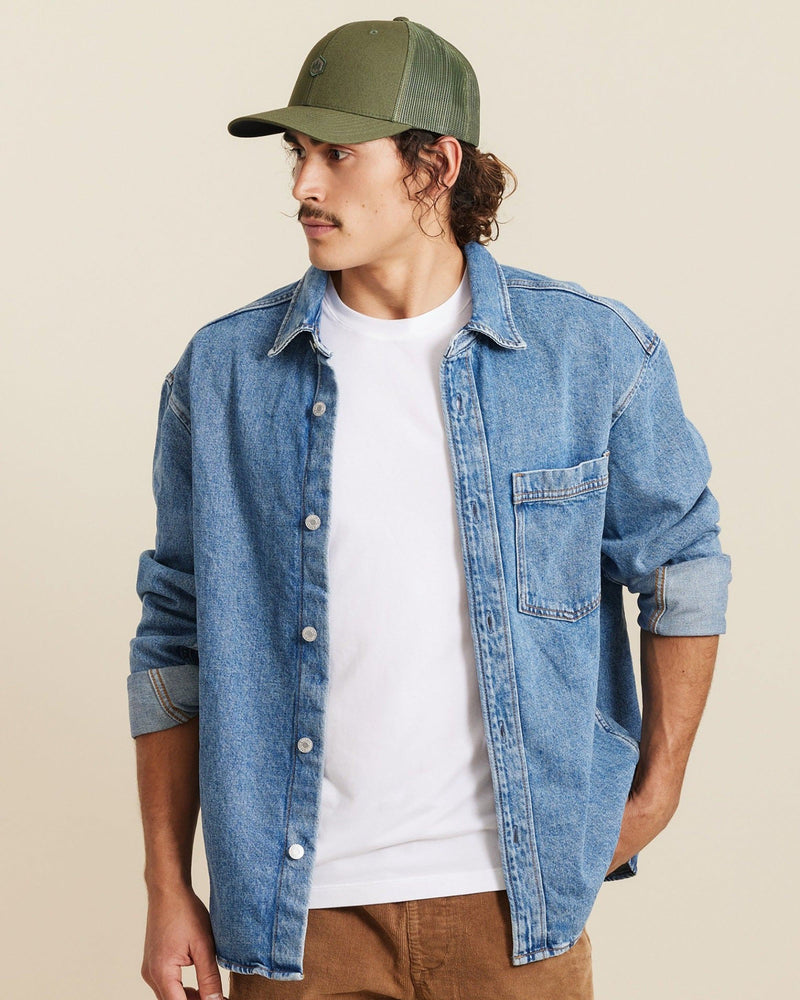Hemlock male model looking left wearing Cooper Trucker Hat in Olive
