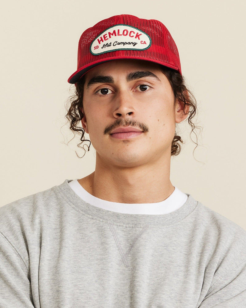 Hemlock male model looking straight wearing Mack Trucker Hat in Red close up