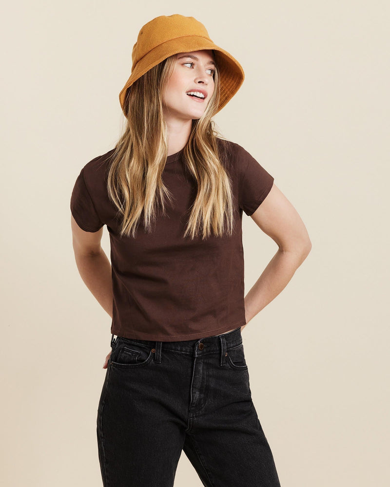 Hemlock female model looking right wearing Marina Terry Bucket Hat in Dijon