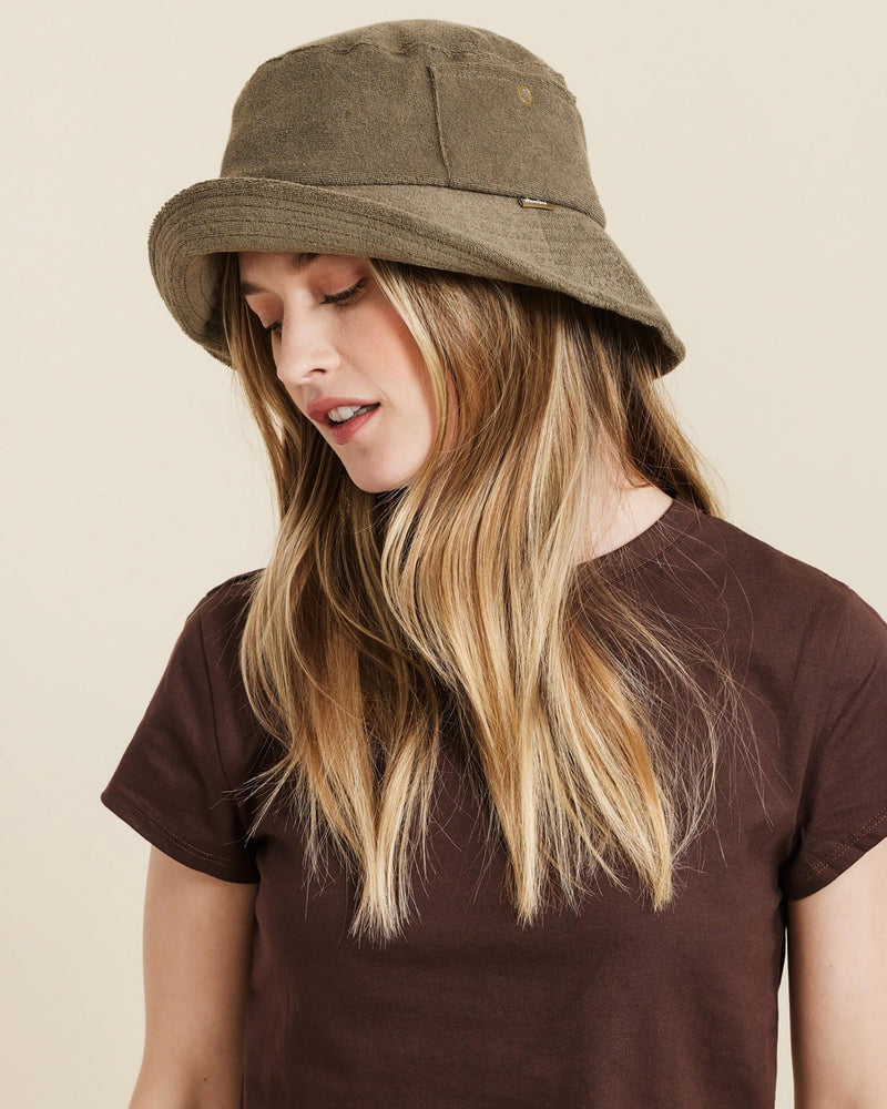Hemlock female model looking down wearing Marina Terry Bucket Hat in Olive