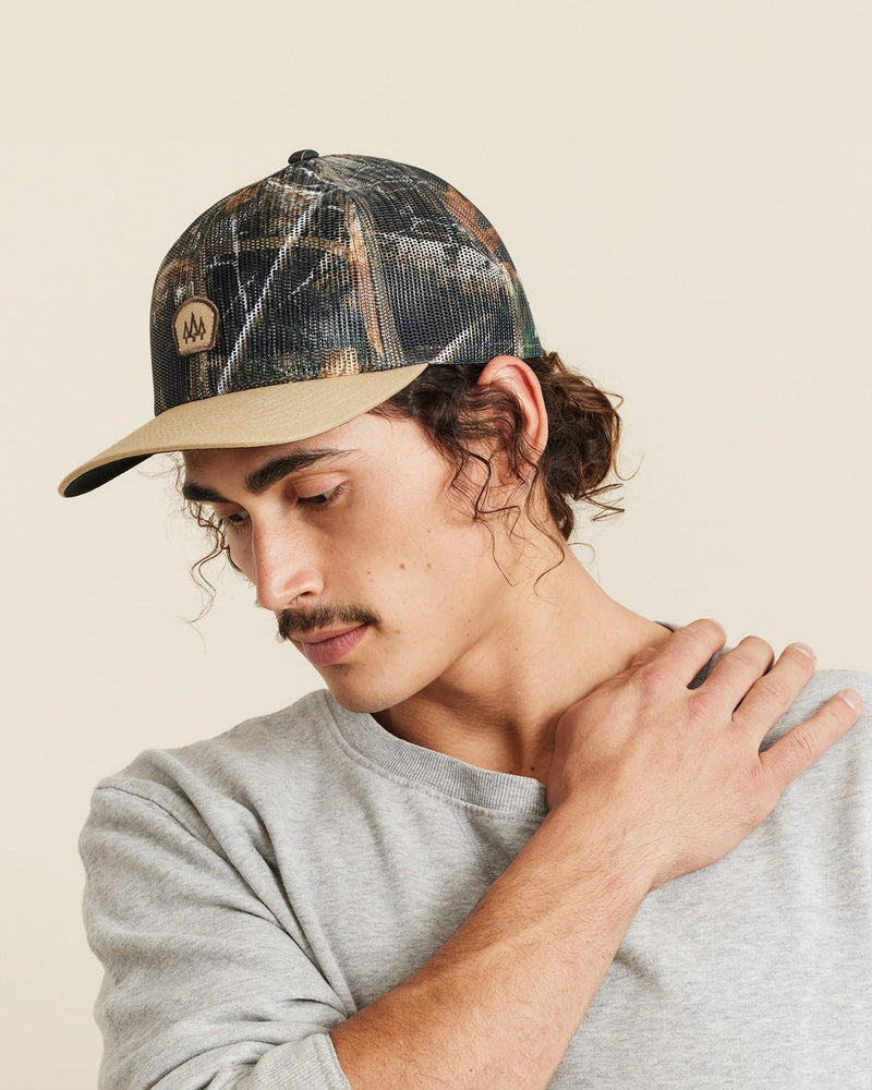 Hemlock male model looking left wearing Raghorn Realtree® Trucker Hat