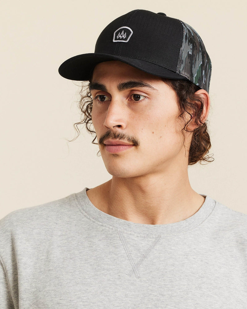 Hemlock male model looking left wearing Trophy Realtree® Trucker Hat close up