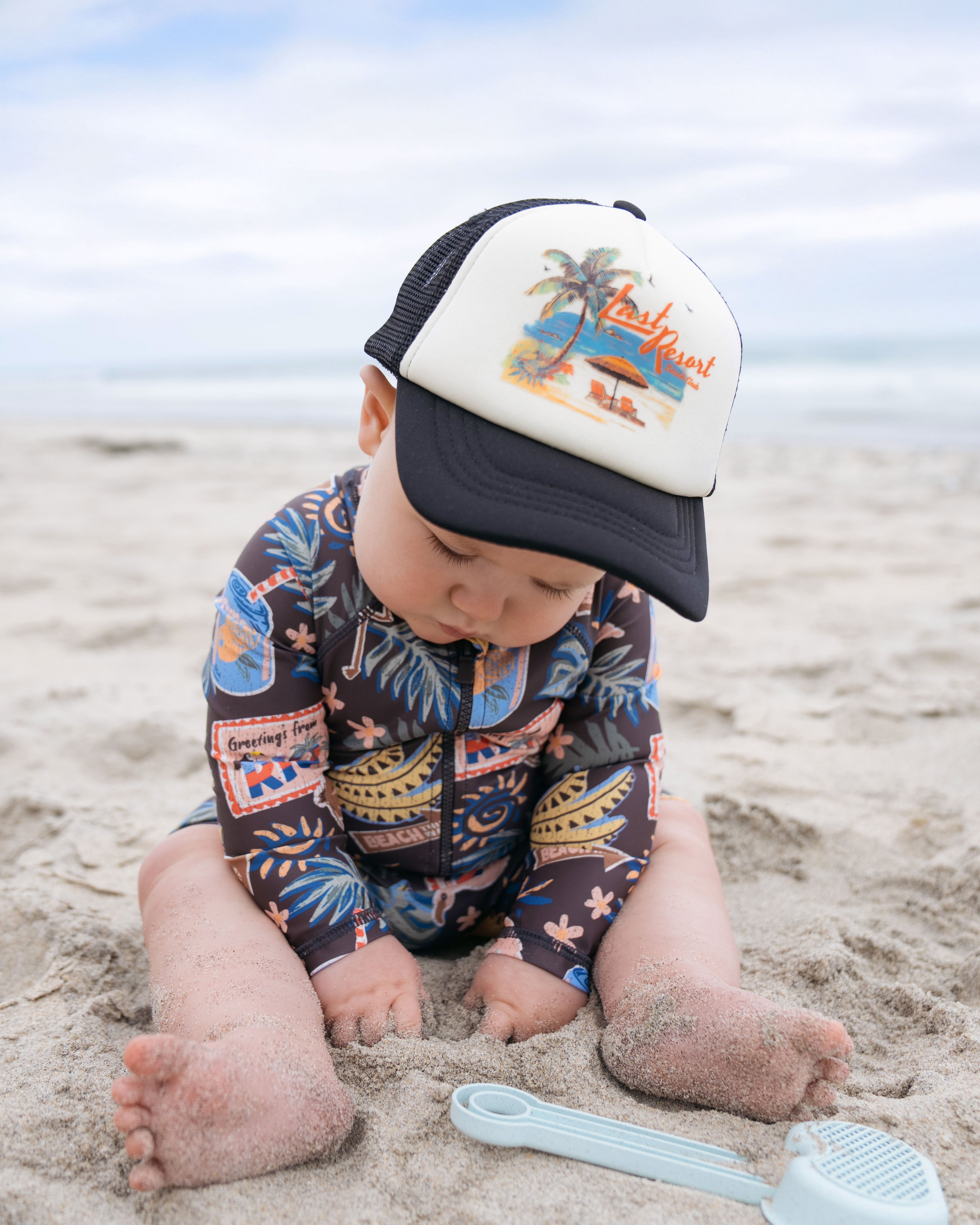 Baby on a beach wearing Hemlock Foam Trucker Ball Cap