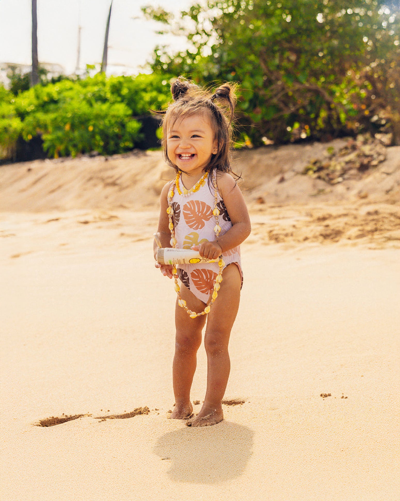 Sun Bum Baby Bum SPF 50 Mineral Sunscreen Lotion 3 oz product front view with little girl holding on the beach