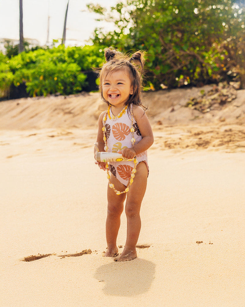 Sun Bum Baby Bum SPF 50 Mineral Sunscreen Lotion 3 oz product front view with little girl holding on the beach
