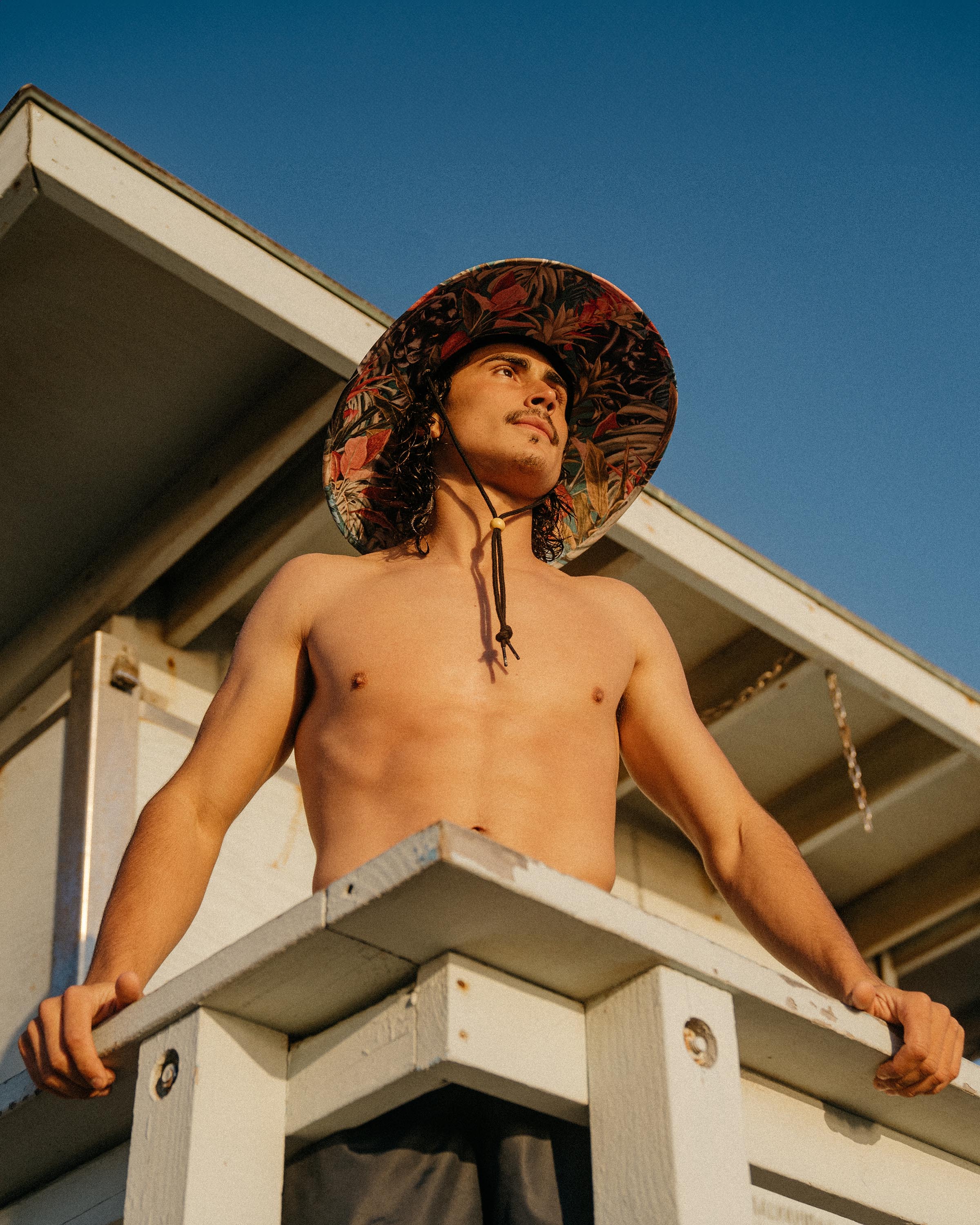 Hemlock male model looking up wearing Bombay straw lifeguard hat with Panther pattern