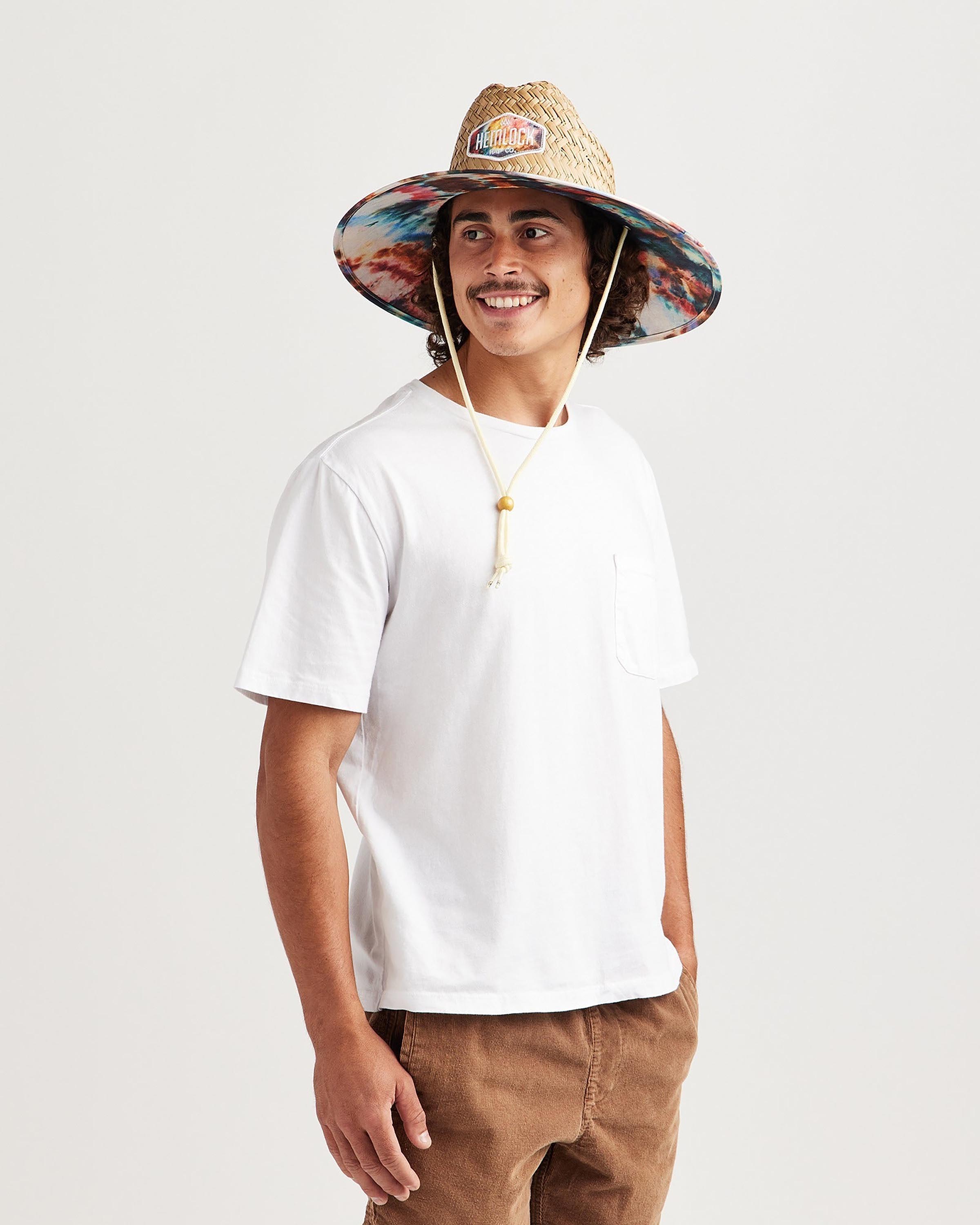 Hemlock male model looking left wearing Bowie straw lifeguard hat with Tie Dye pattern