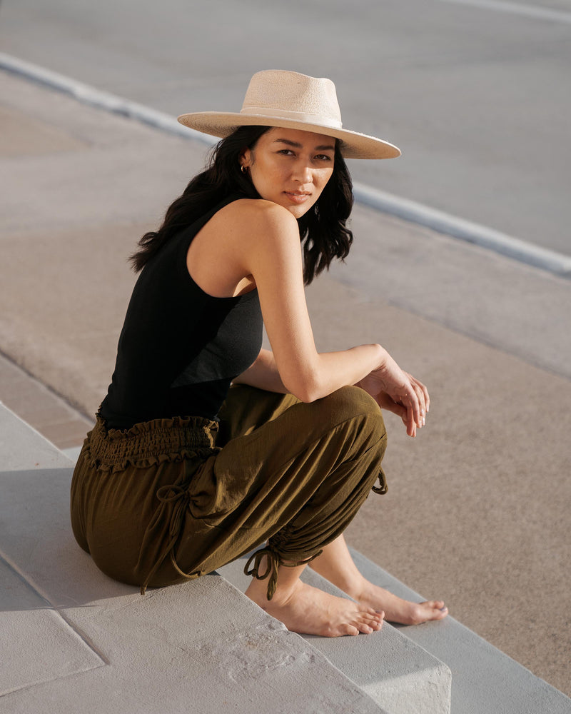 Hemlock female model looking over her shoulder wearing Cruz Straw Fedora in Sand color