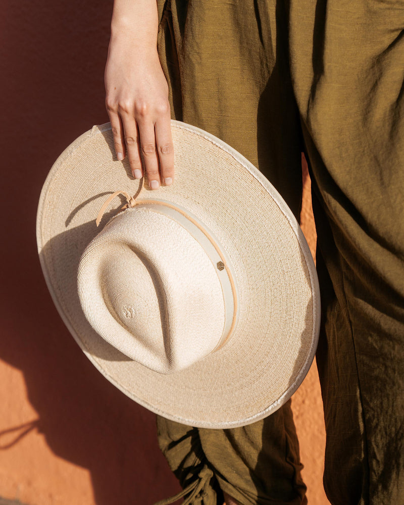 Hemlock female model holding Cruz Straw Fedora in Sand color