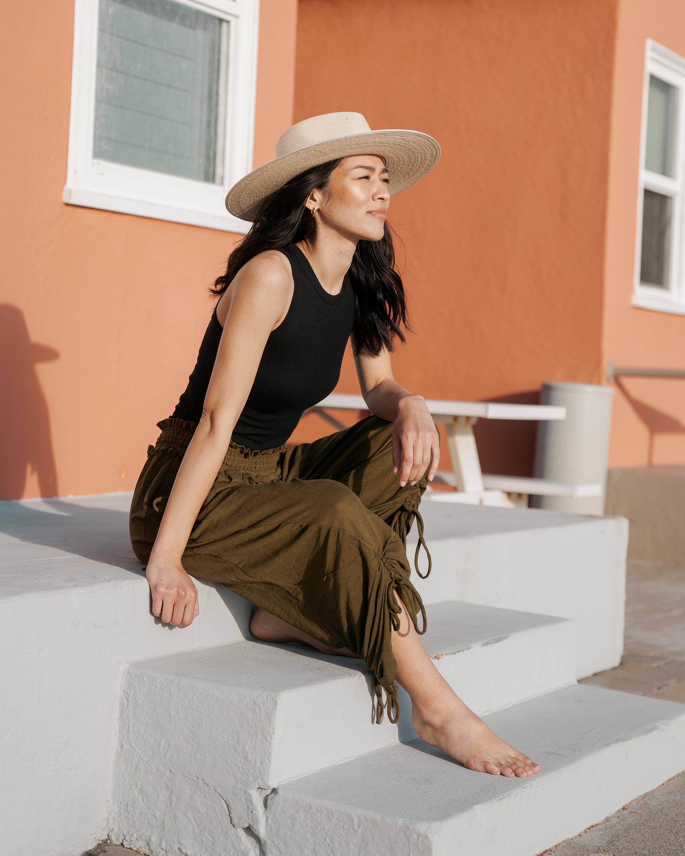 Hemlock female model looking right wearing Cruz Straw Fedora in Sand color