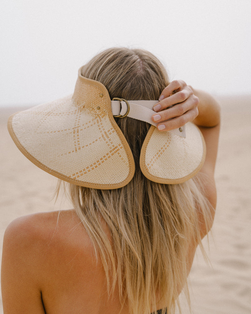 Hemlock female model adjusting the Luna Packable Wide Brim Visor in Sand