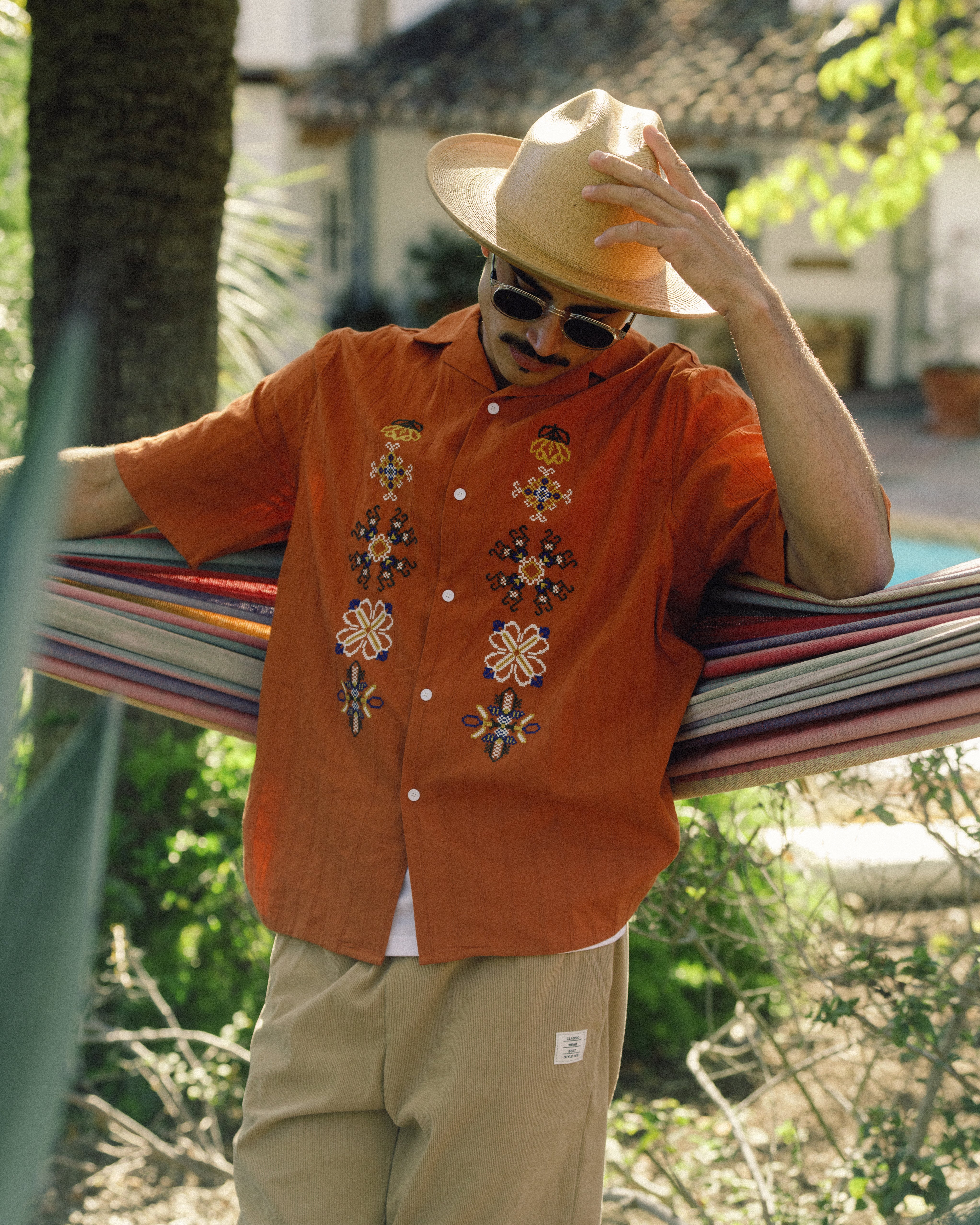 Hemlock male model wearing Hemlock Mateo Straw Rancher Hat in Saddle fixing hat