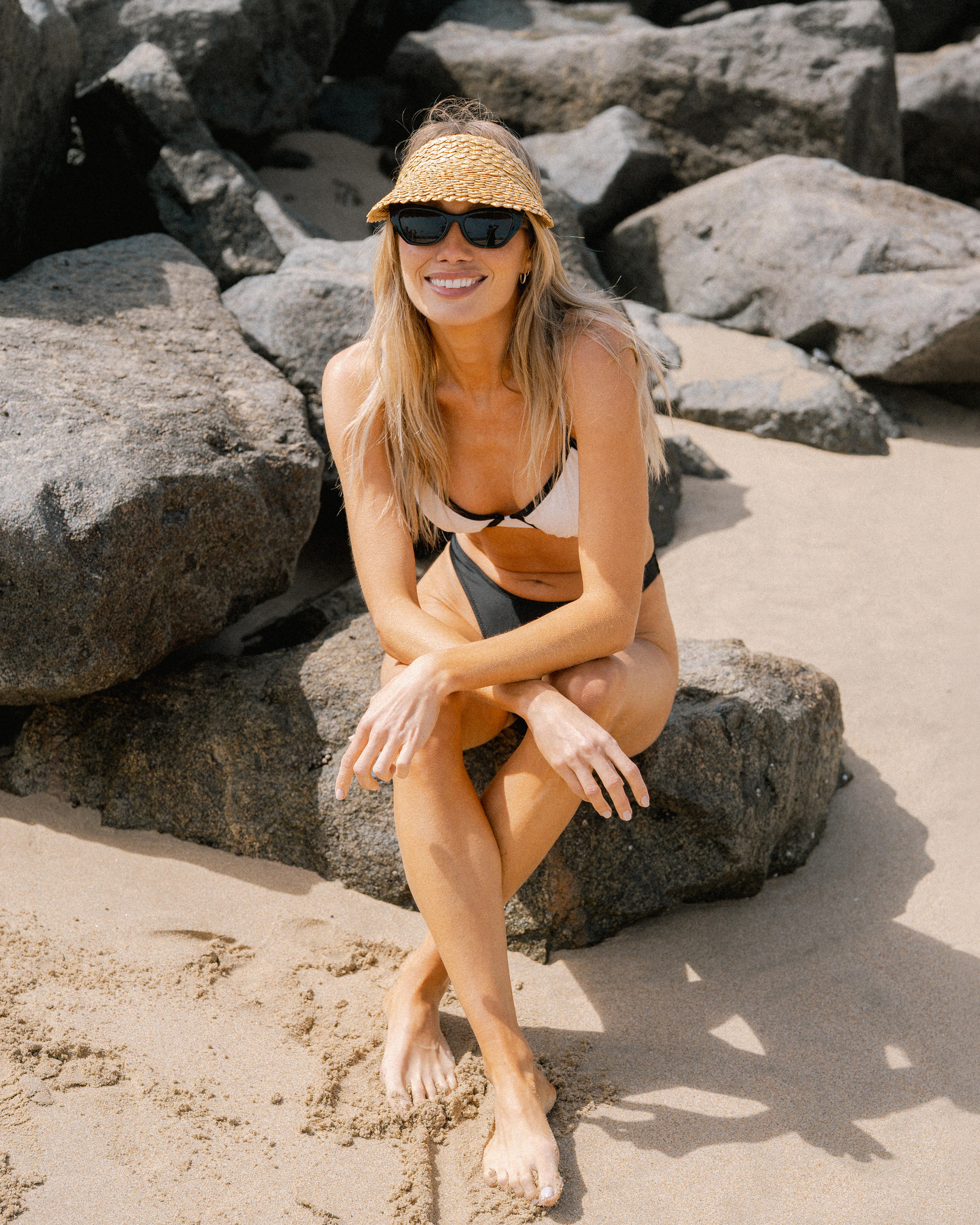 Hemlock female model wearing the Capri Visor in Honeycomb color smiling