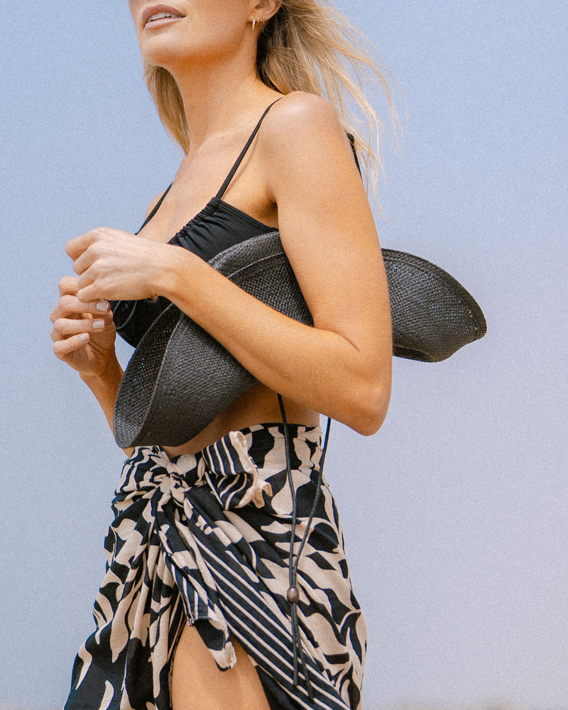 Hemlock female model holding the Las Olas packable lifeguard in Black folded