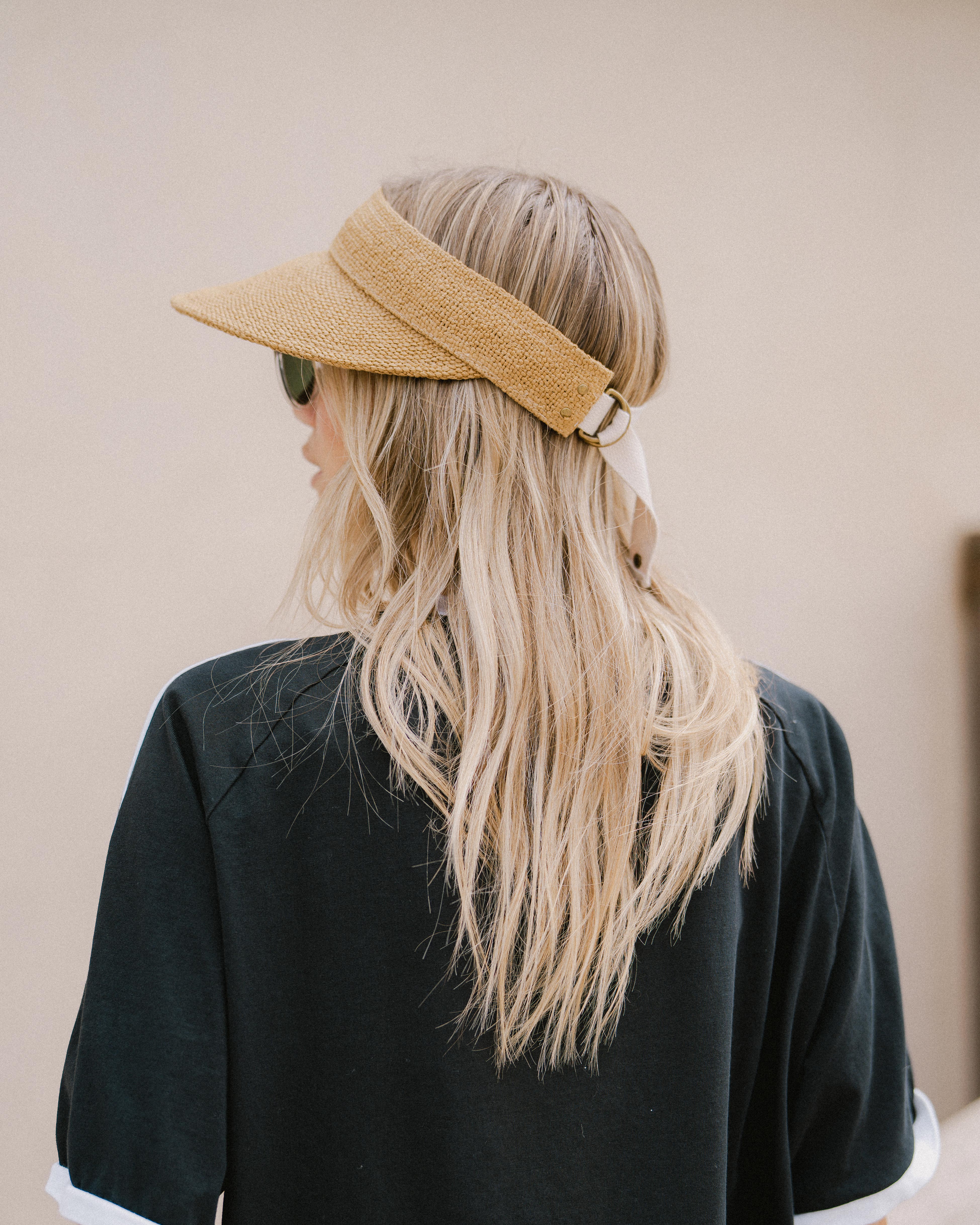 Hemlock female model wearing the Perla packable visor in tan side view