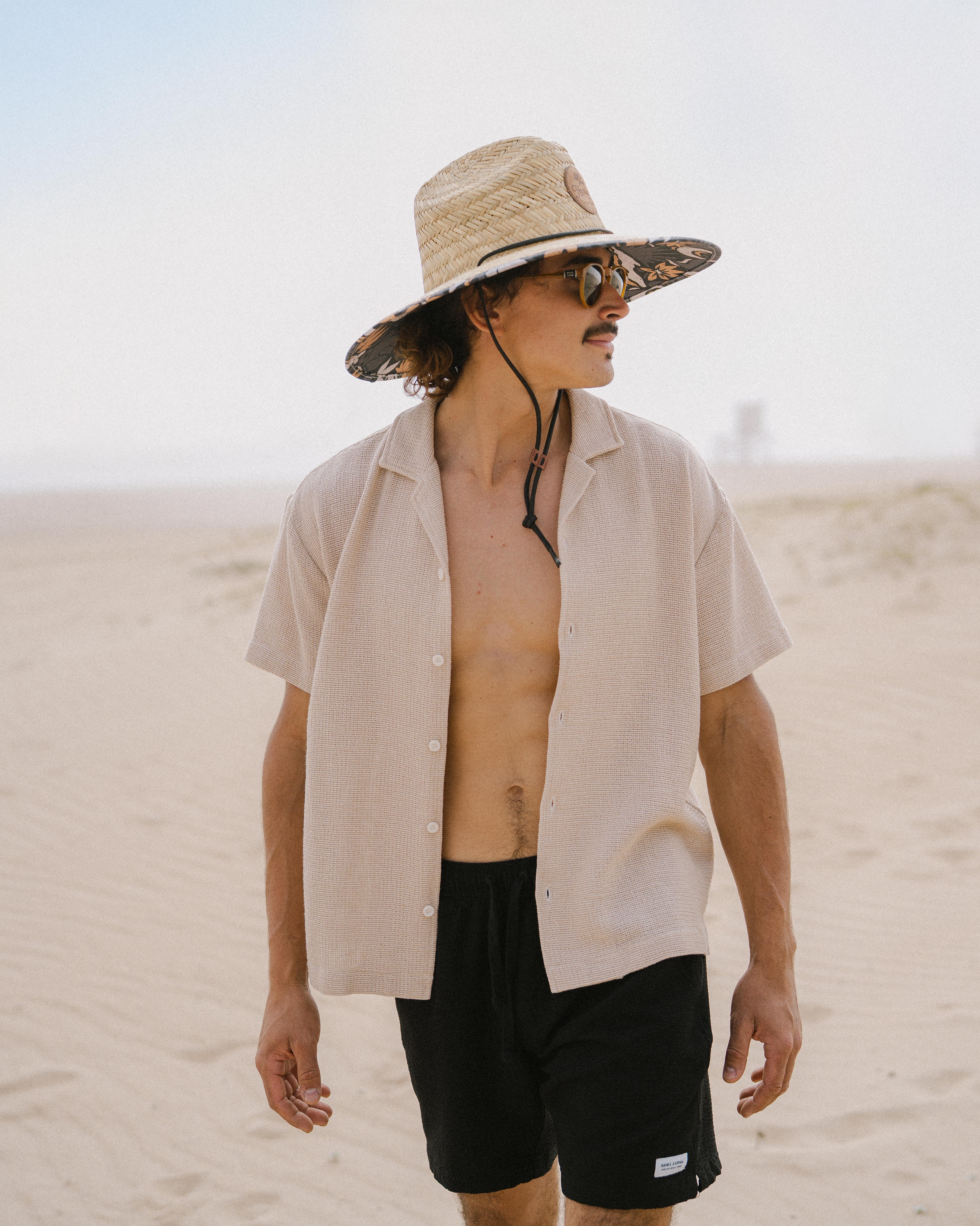 Hemlock male Model wearing the
UPF50+ Lifeguard hat in Desert Bloom
print at the beach