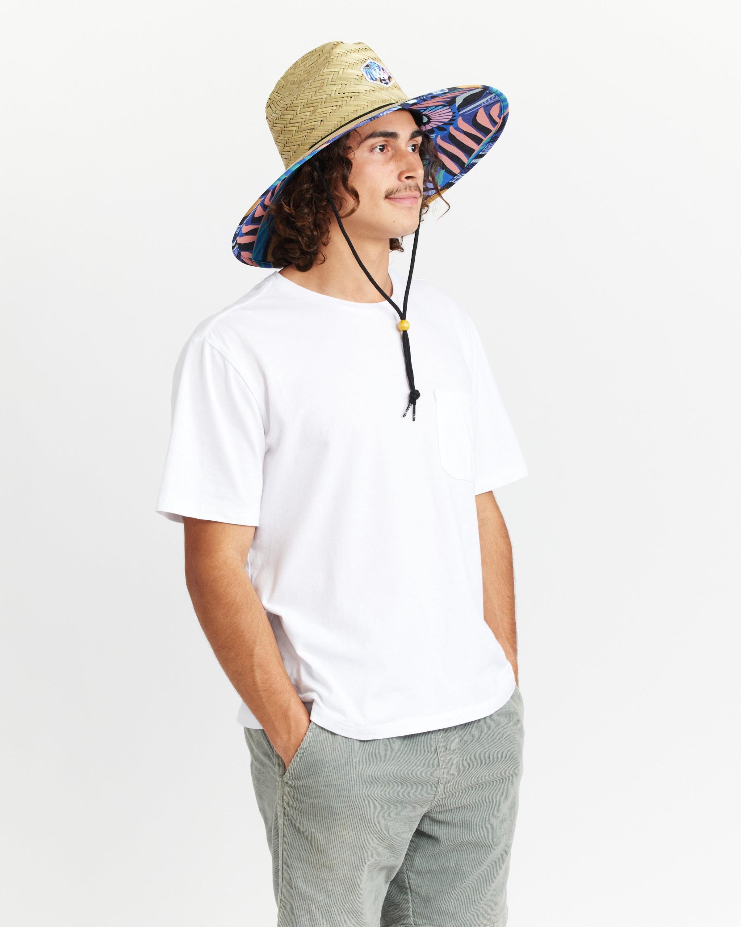 Hemlock male model looking right wearing Eden straw lifeguard hat with purple floral pattern