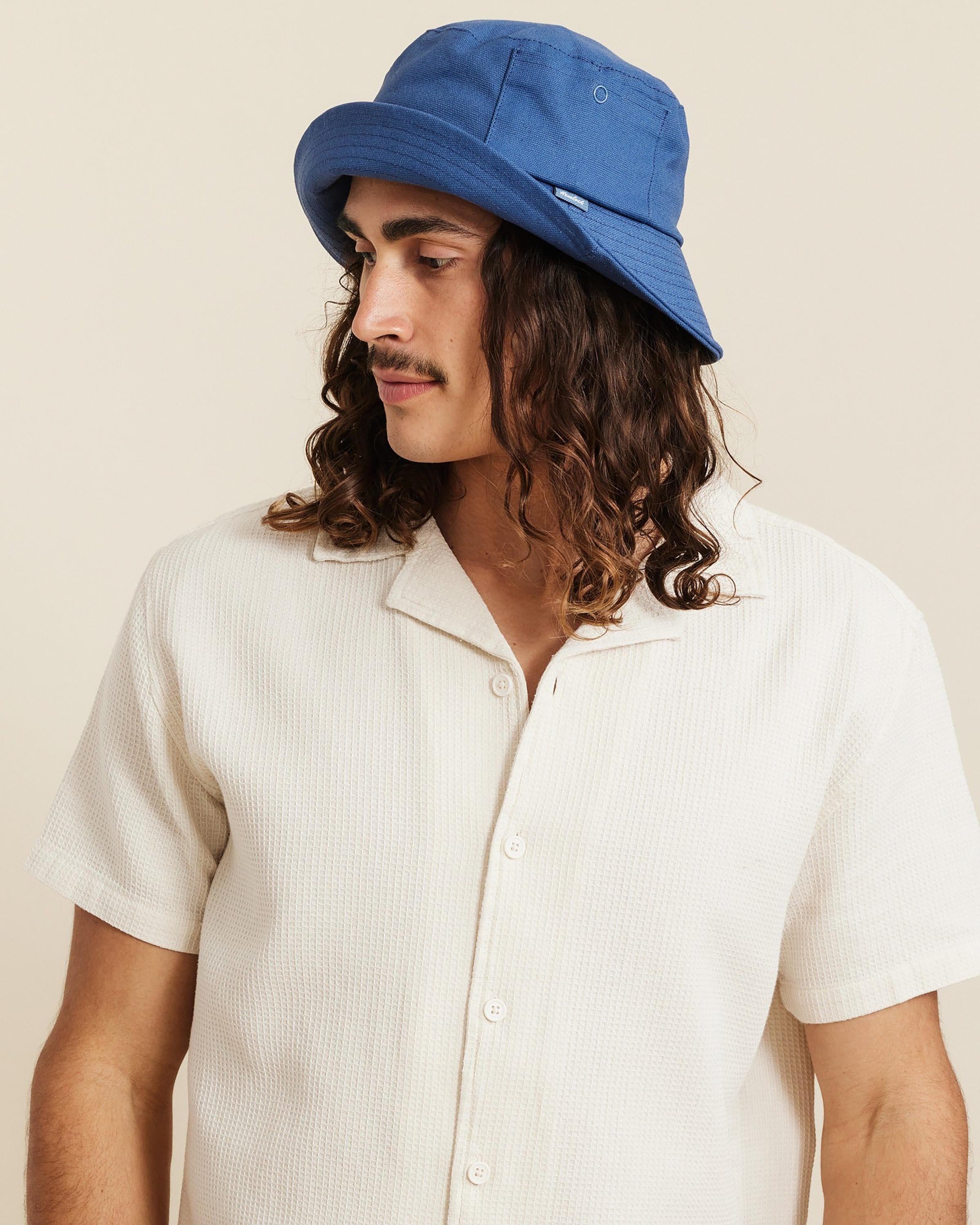 Hemlock male model looking left wearing Isle Cotton Bucket Hat in Indigo