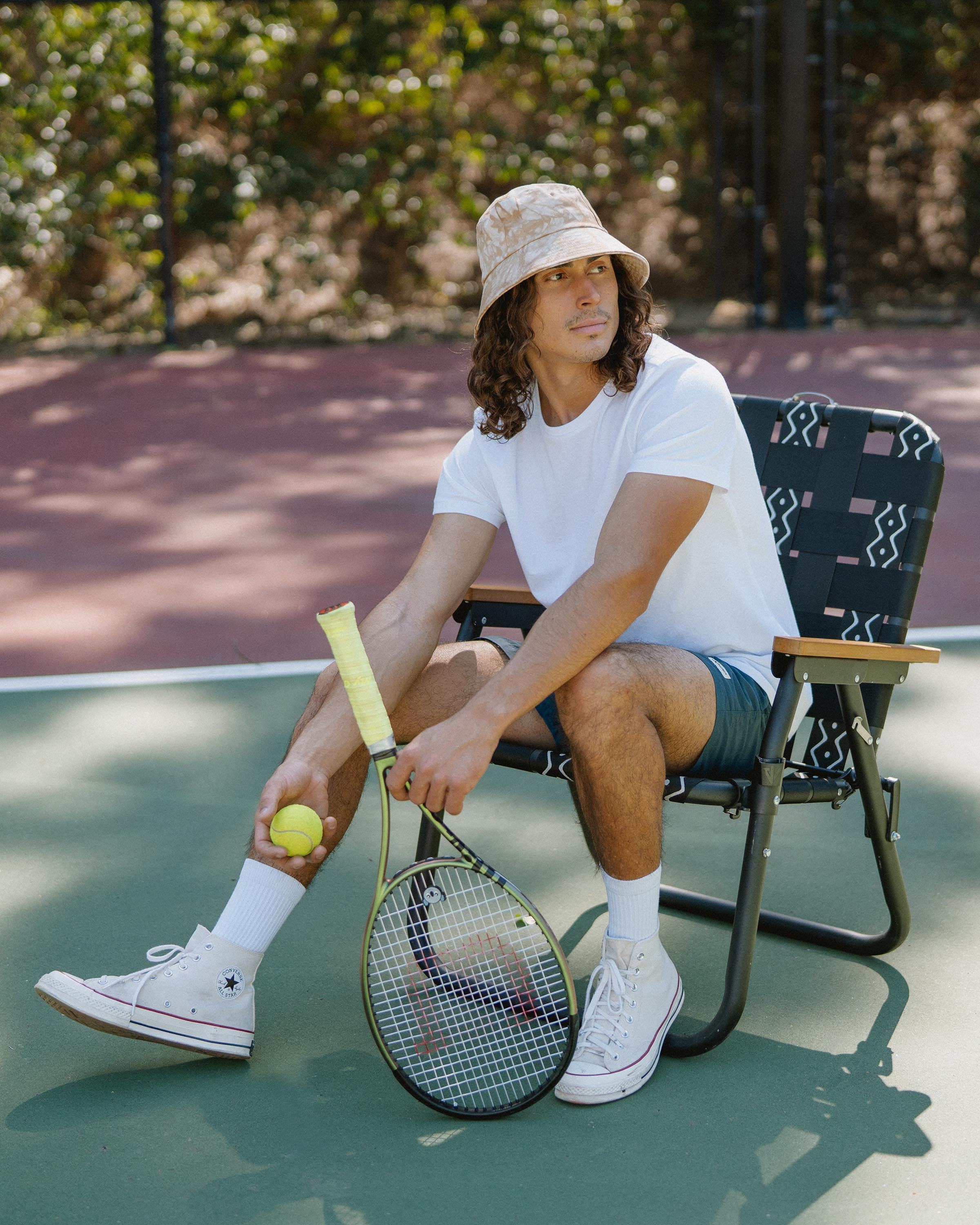 Hemlock male model looking right wearing Isle Cotton Bucket Hat in Saffron Tie-dye