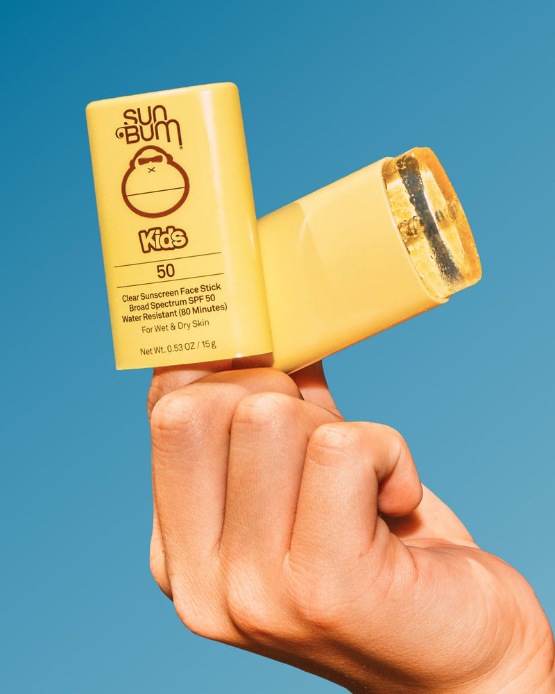 Kids SPF 50 Clear Sunscreen Face Stick 
 with child holding product in hand.