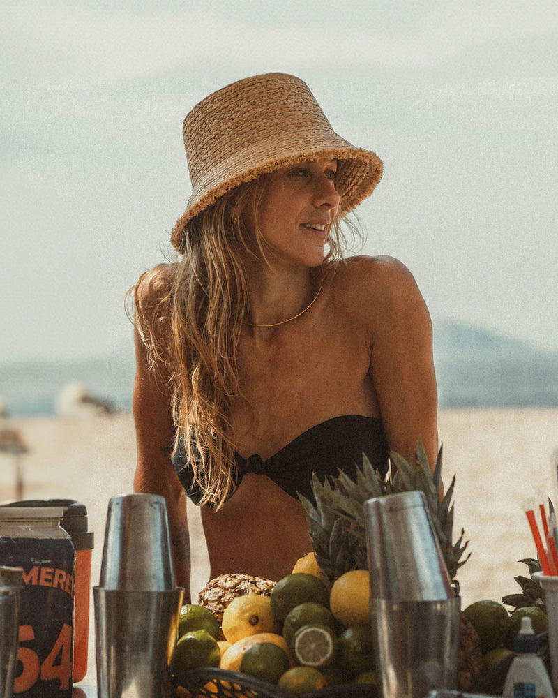 Hemlock female model looking right wearing Lenny Straw Bucket Hat in Natural