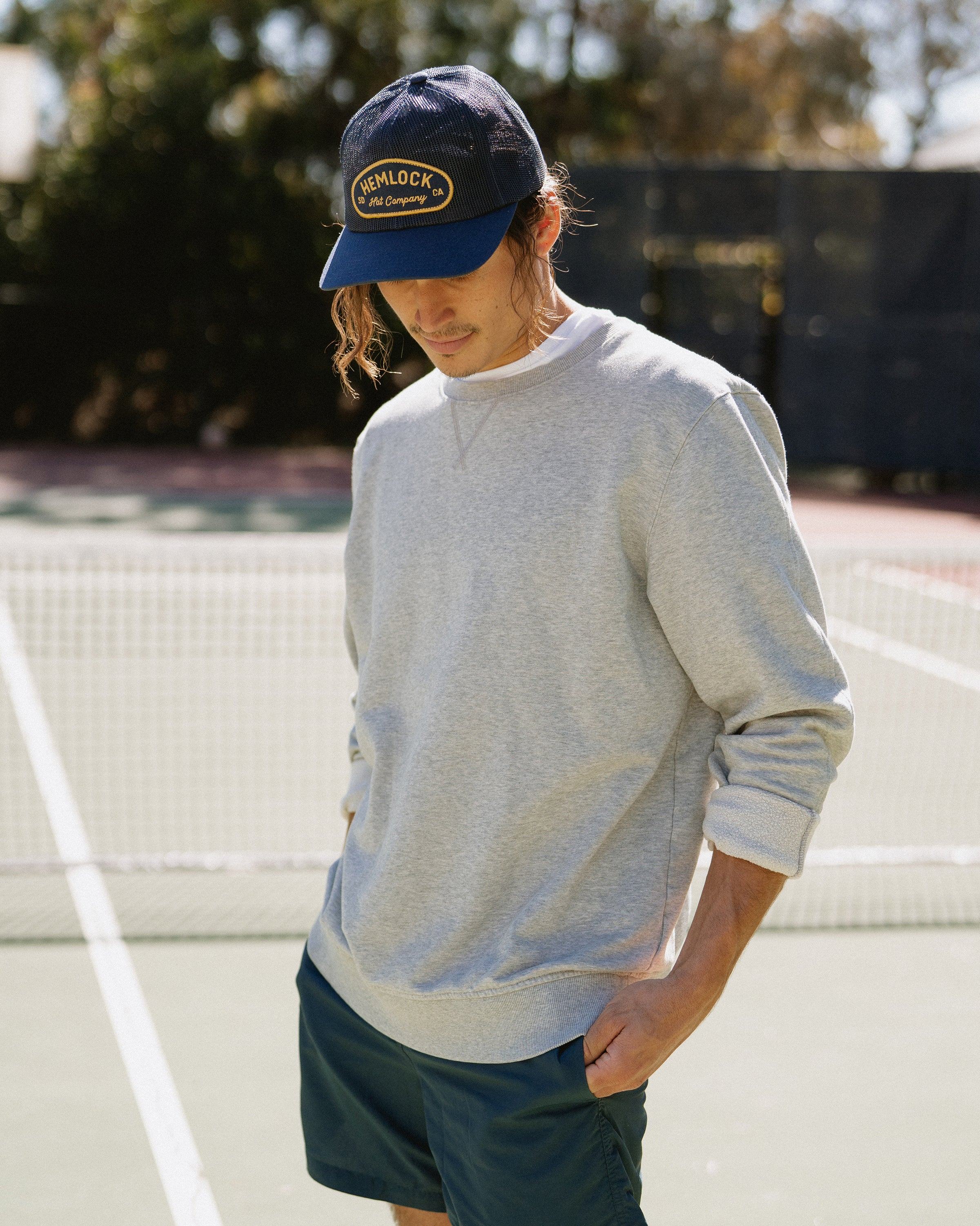 Hemlock male model looking down wearing Mack Trucker Hat in Navy