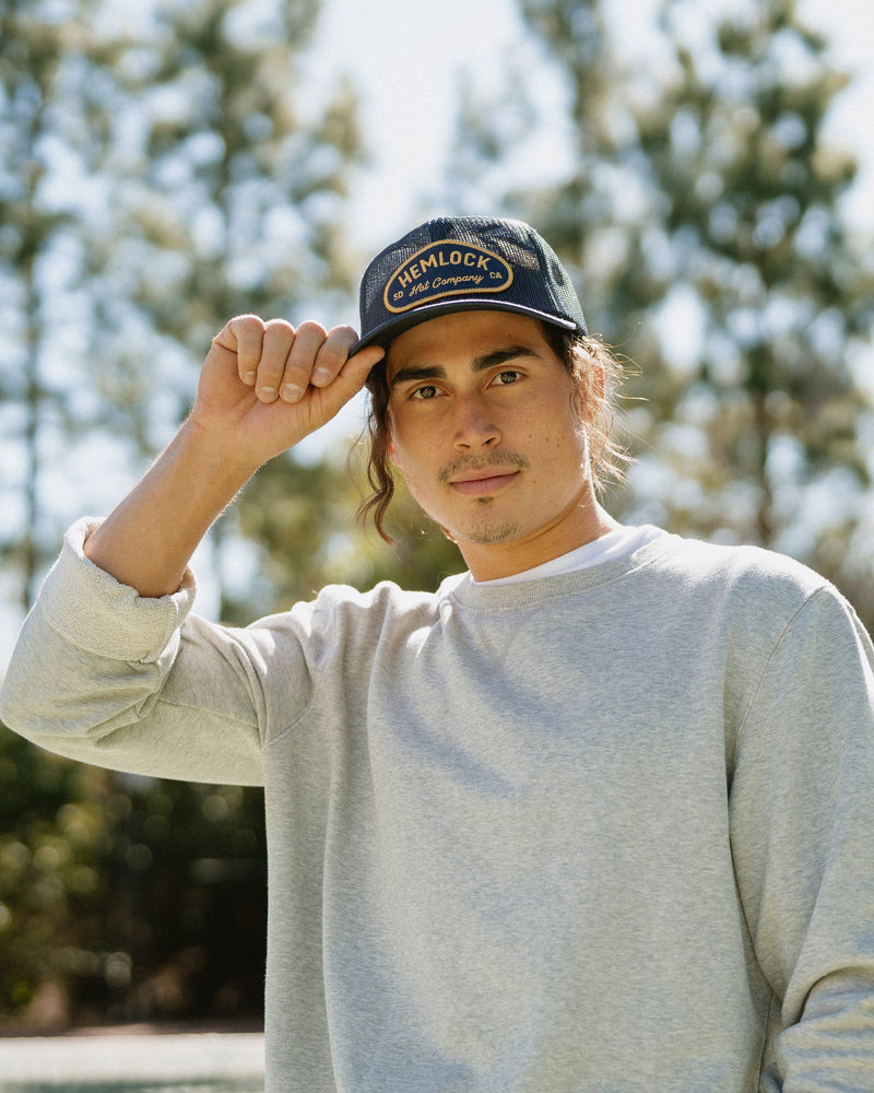 Hemlock male model looking straight wearing Mack Trucker Hat in Navy close up