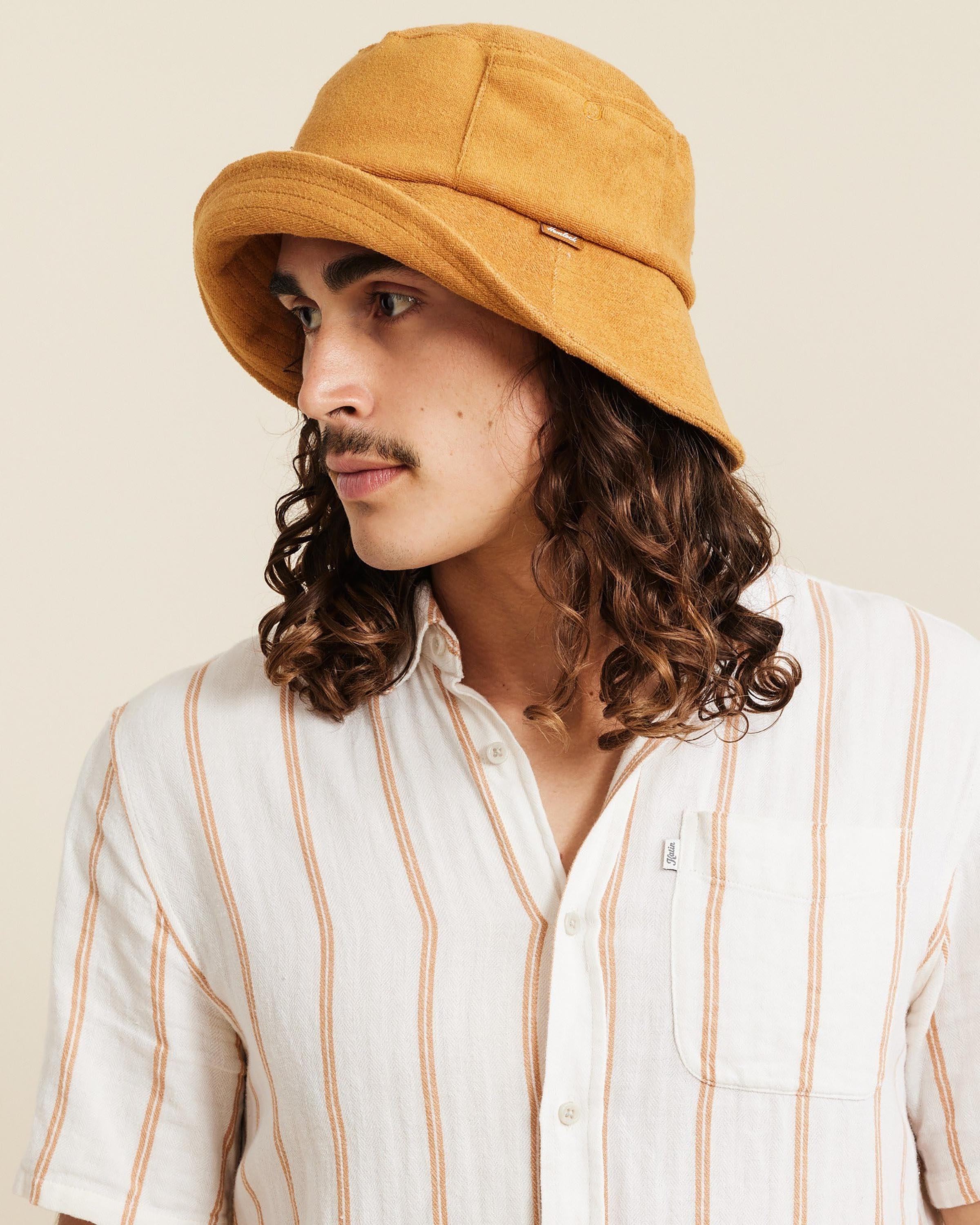 Hemlock male model looking left wearing Marina Terry Bucket Hat in Dijon