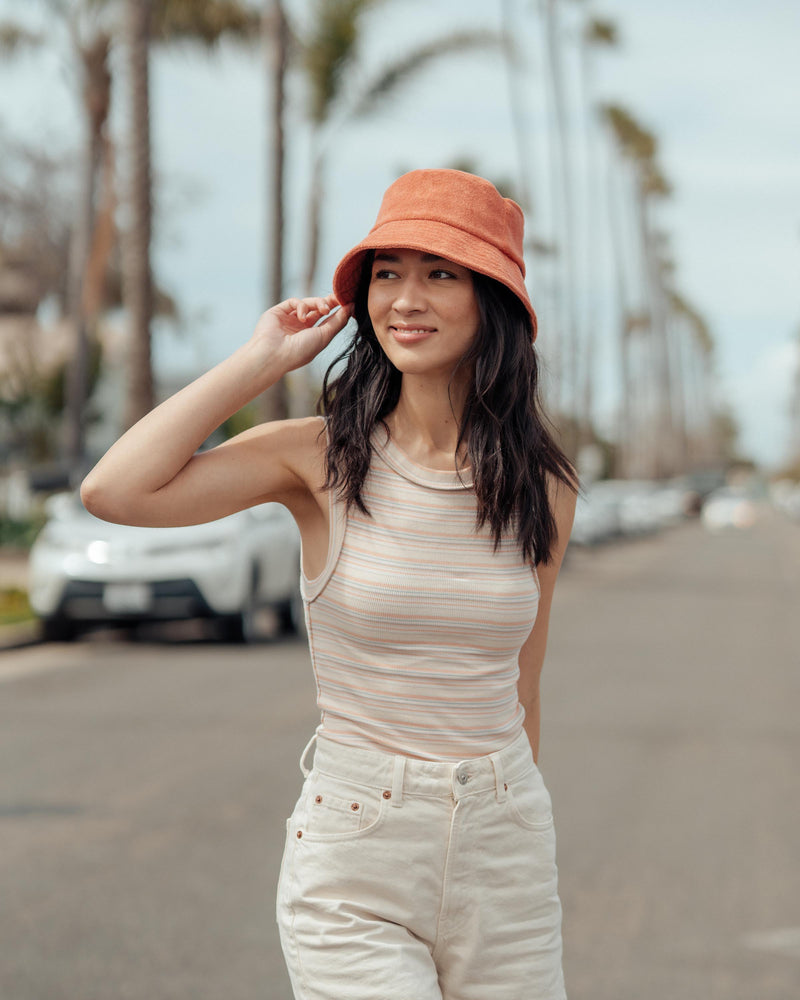 Hemlock female model looking left wearing Marina Terry Bucket Hat in Red Clay