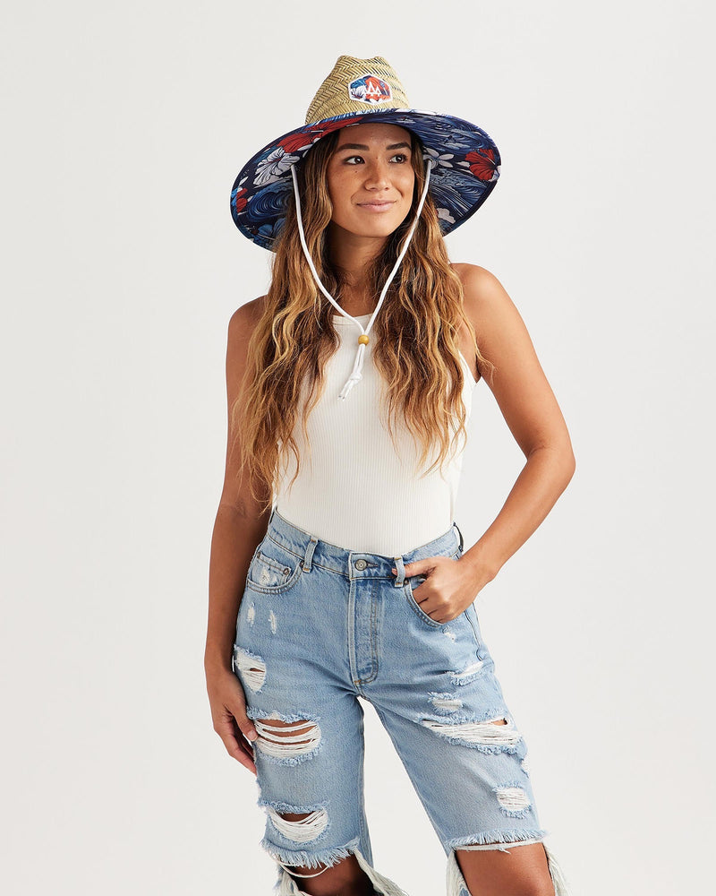 Hemlock female model looking right wearing Midway straw lifeguard hat with USA floral pattern