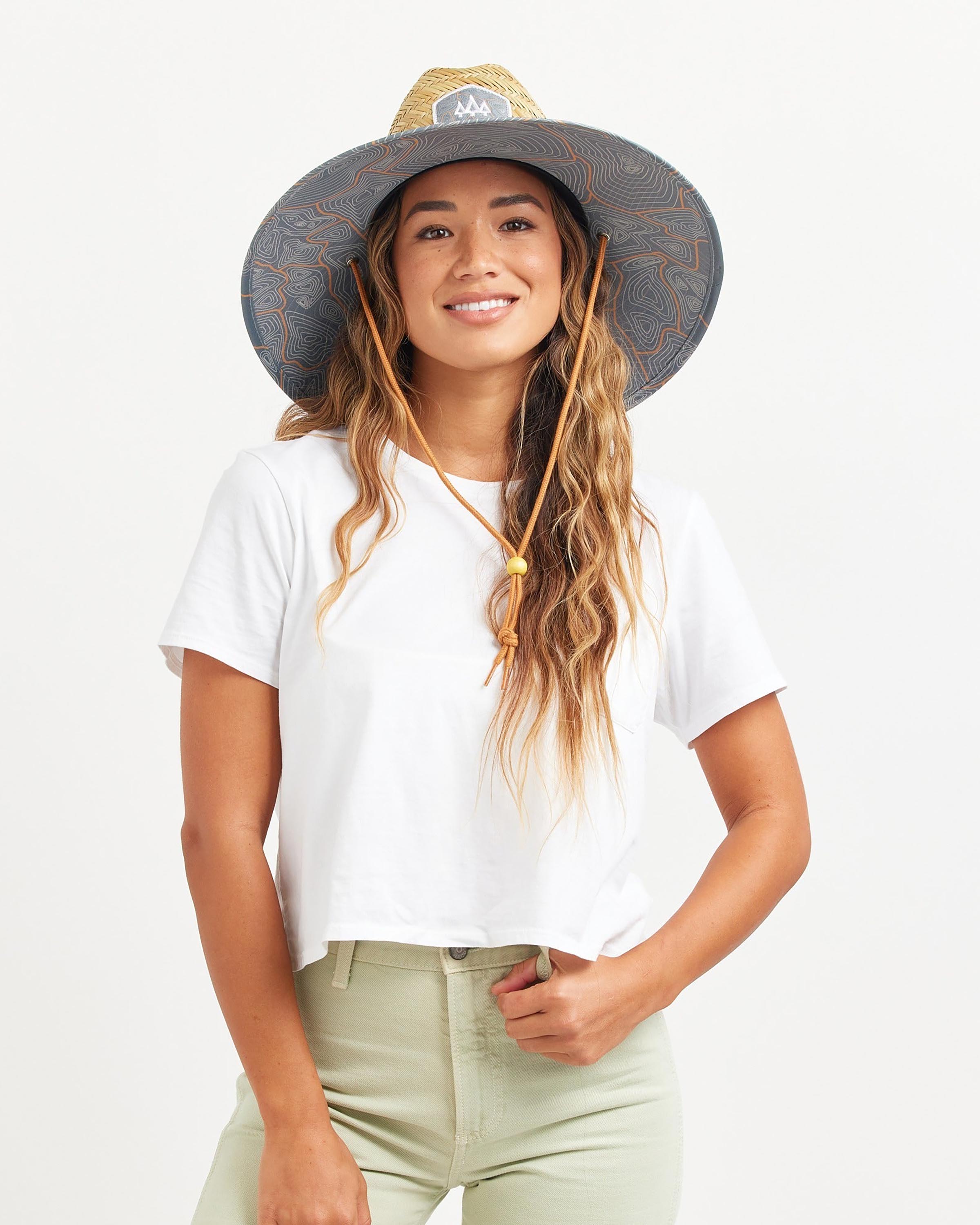Hemlock female model looking straight wearing Nomad straw lifeguard hat with topography pattern