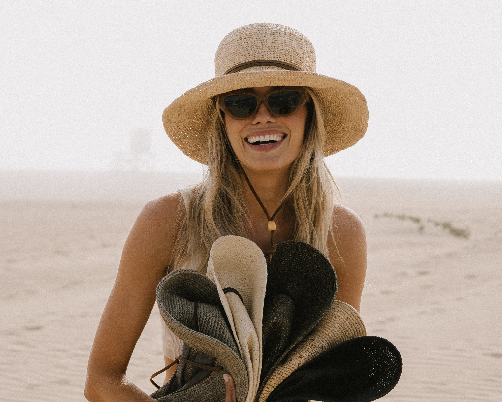 hemlock female model wearing the bondi bucket packable hat and holding 5 packable hats 