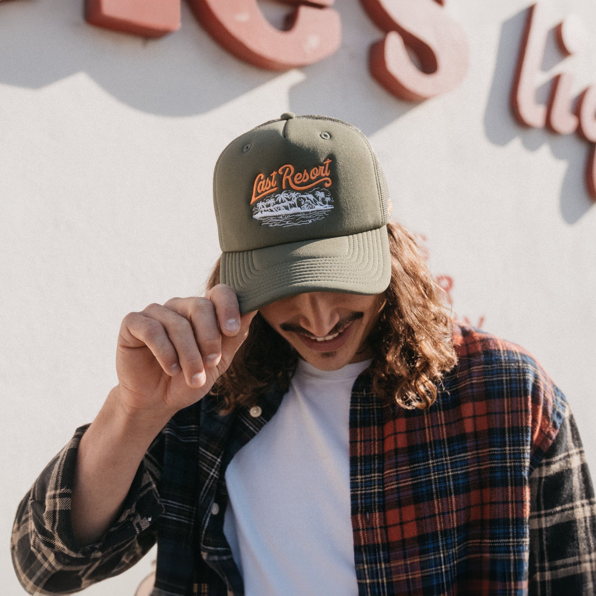 Male model wearing Last Resort foam trucker hat. 