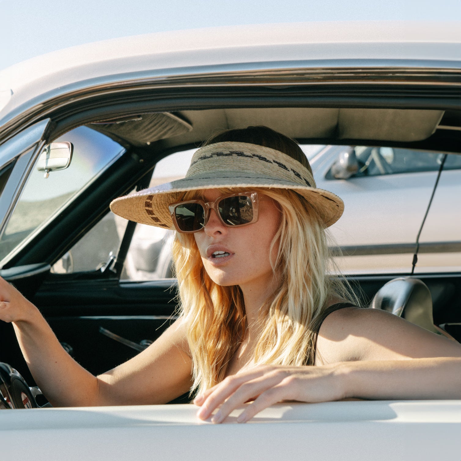 Female model wearing Catalina Visor in vintage mustang.