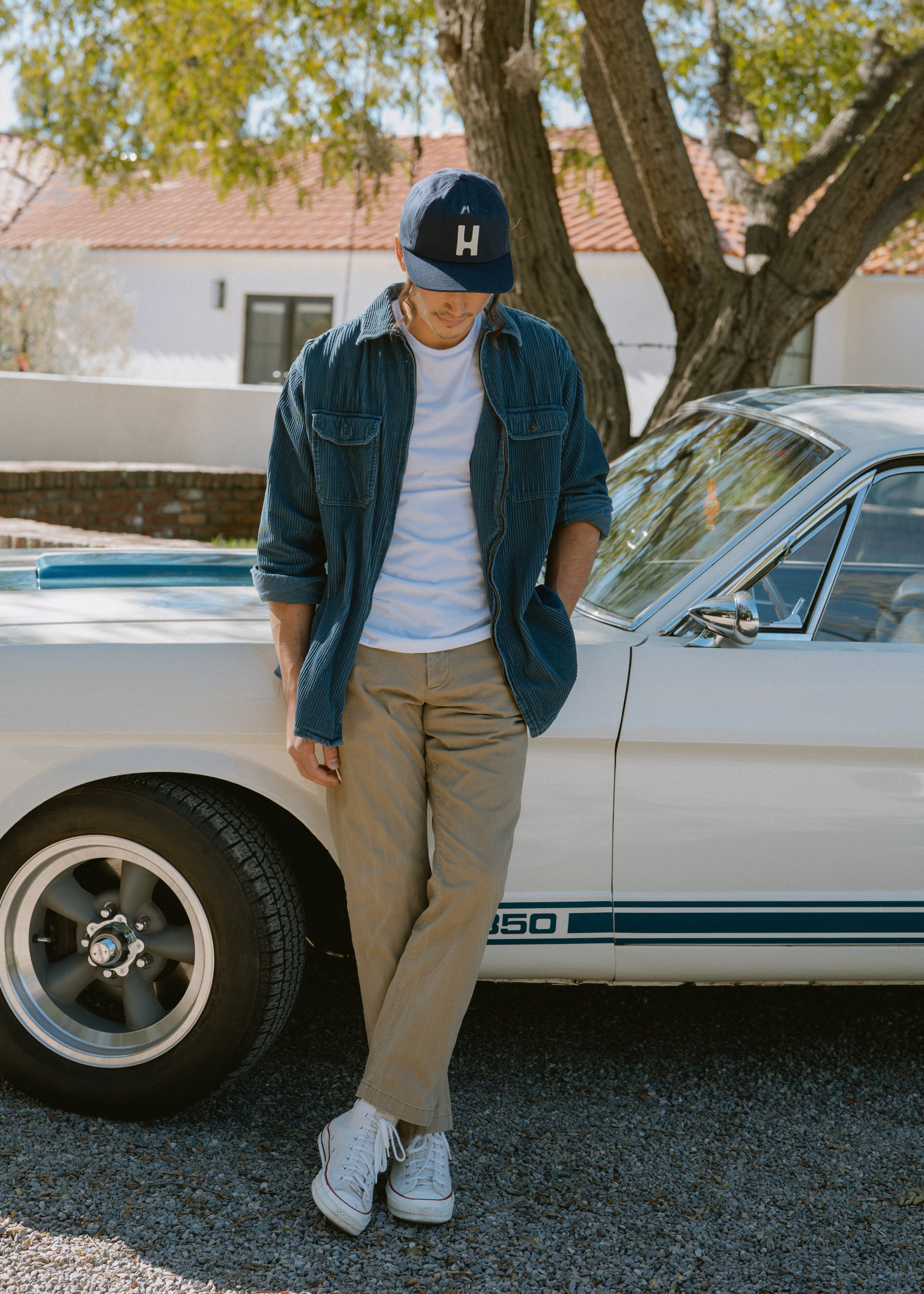 Hemlock male model looking down wearing Thomas Baseball Hat in Navy