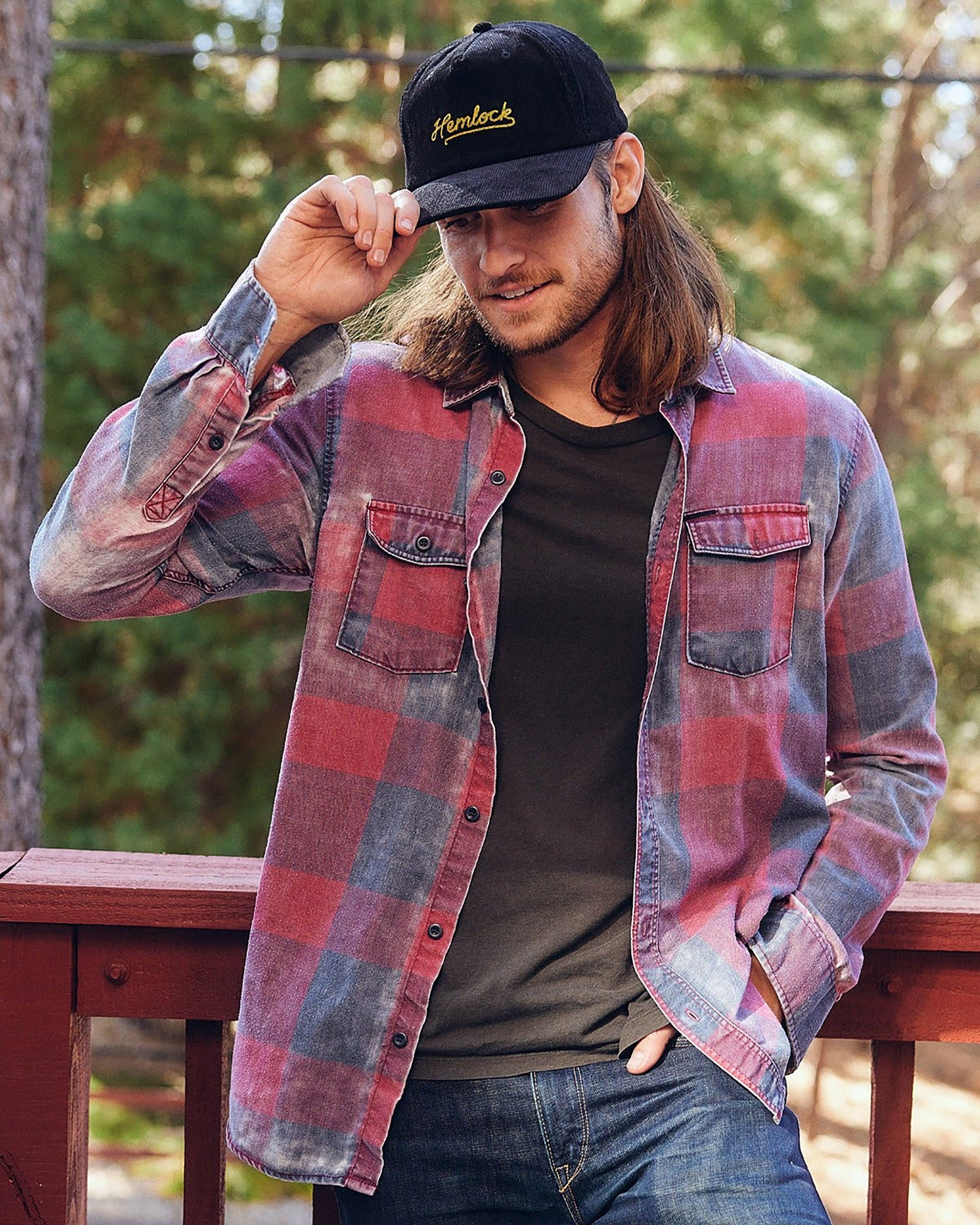 Hemlock male model looking down wearing Hemlock Wesley Corduroy Baseball Hat in Black in cabin