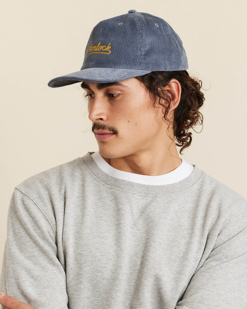 Hemlock male model looking left wearing Hemlock Wesley Corduroy Baseball Hat in Dusty Blue