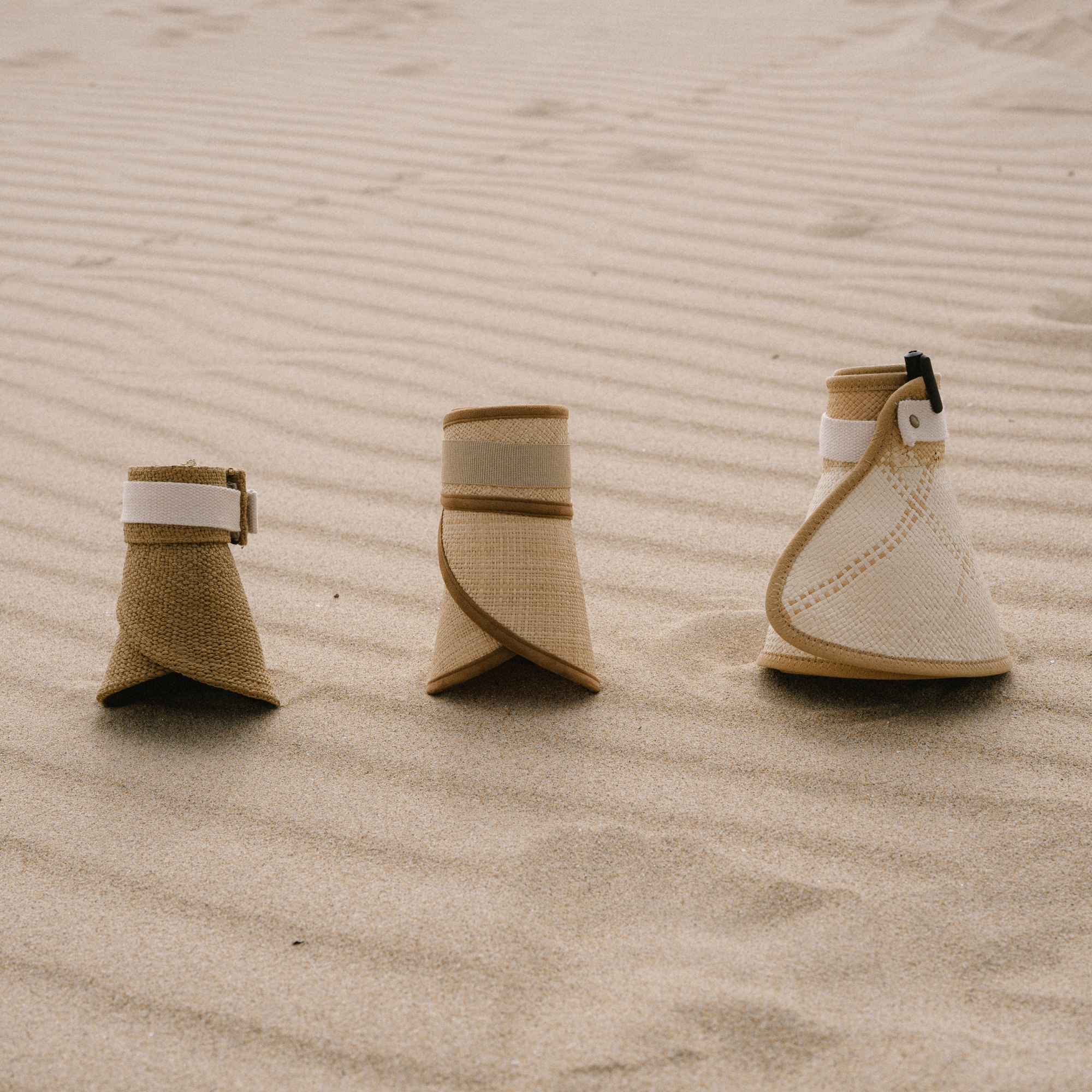Packable visors rolled up on sand