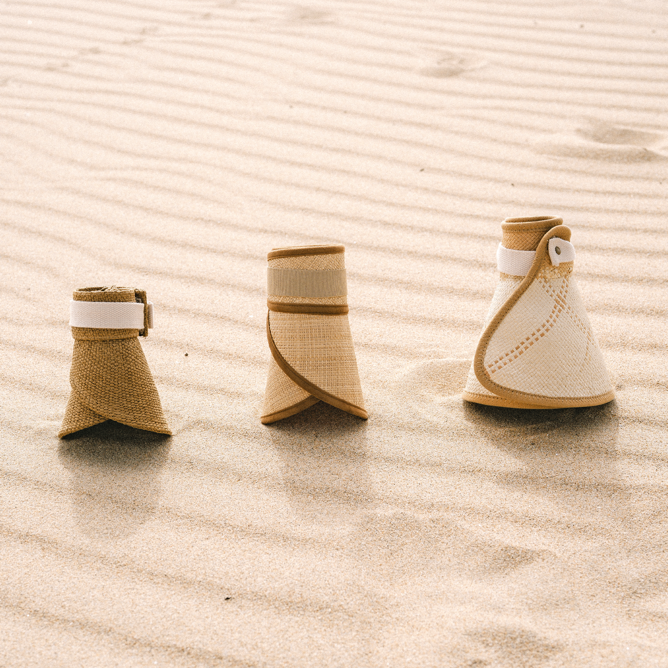 Perla, Solana and Luna Packable visors rolled up on sand