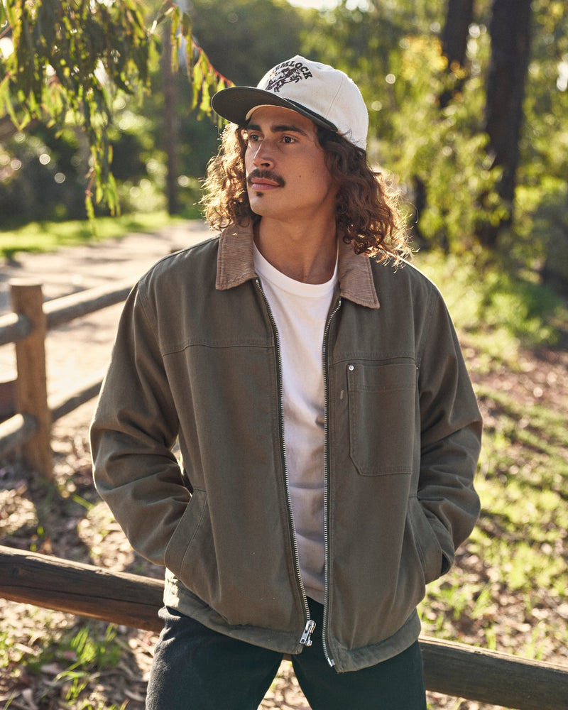 Hemlock male model wearing the Buckin Baseball Hat Green looking left