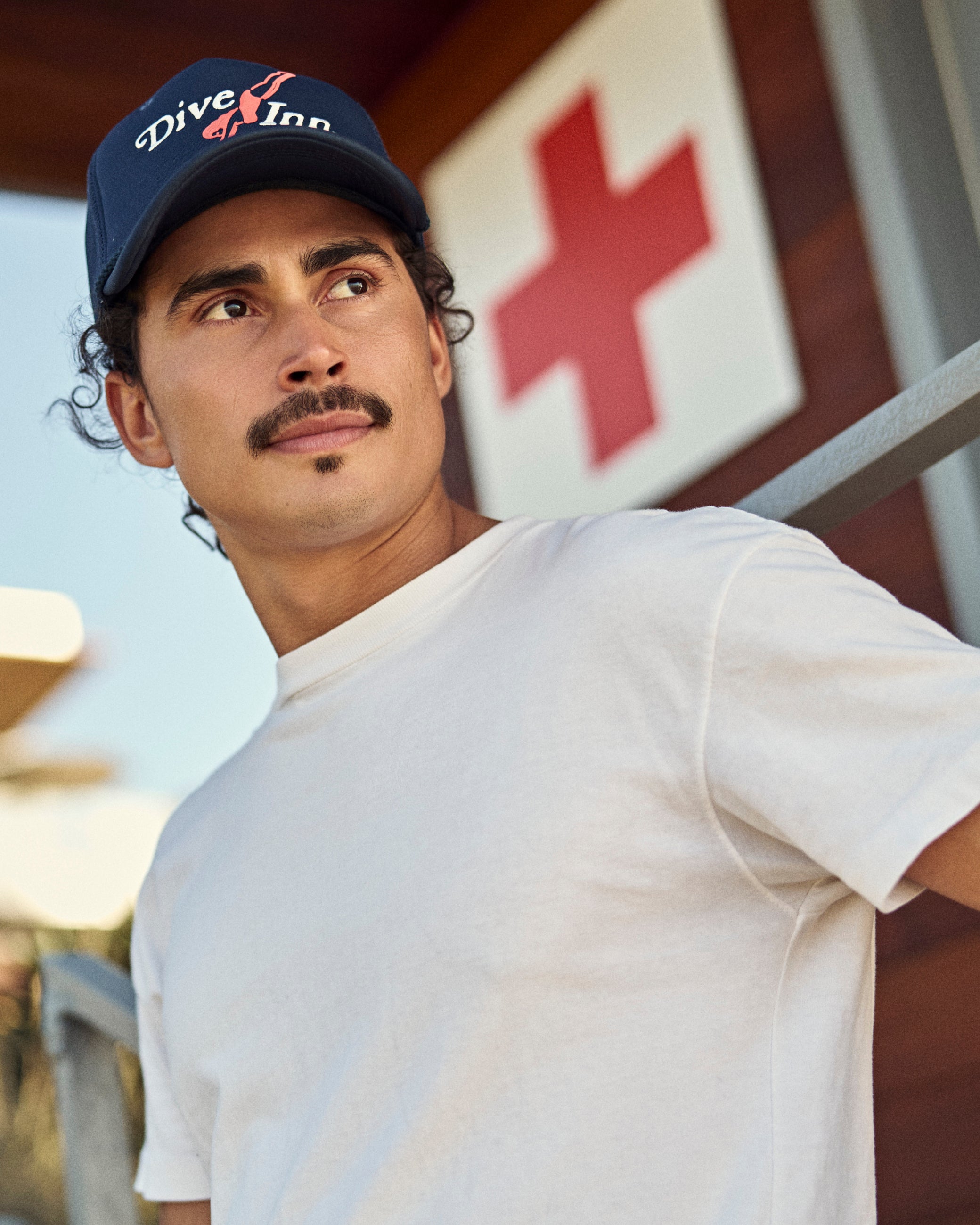 Hemlock male model wearing the Navy blue Trucker Hat with 'Dive Inn' logo 