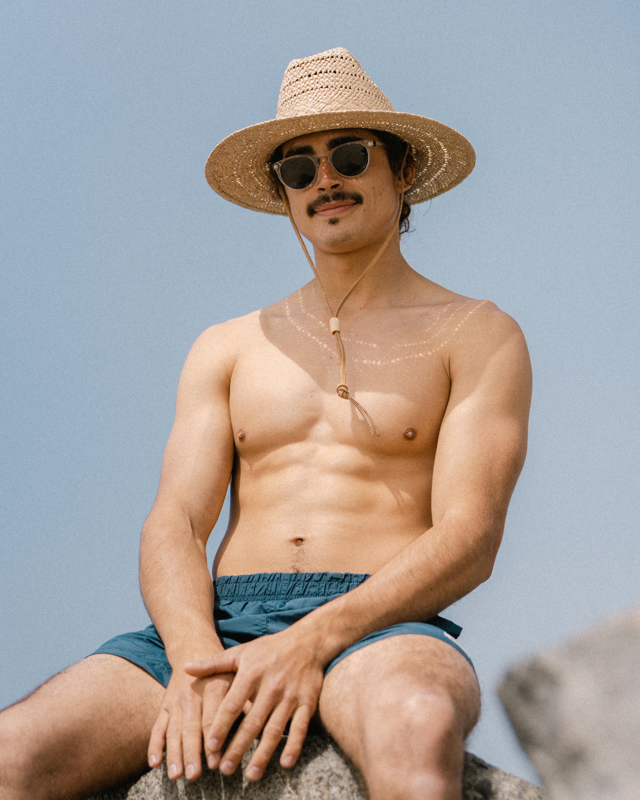 Hemlock male model wearing Grandview Straw hat at a beach 