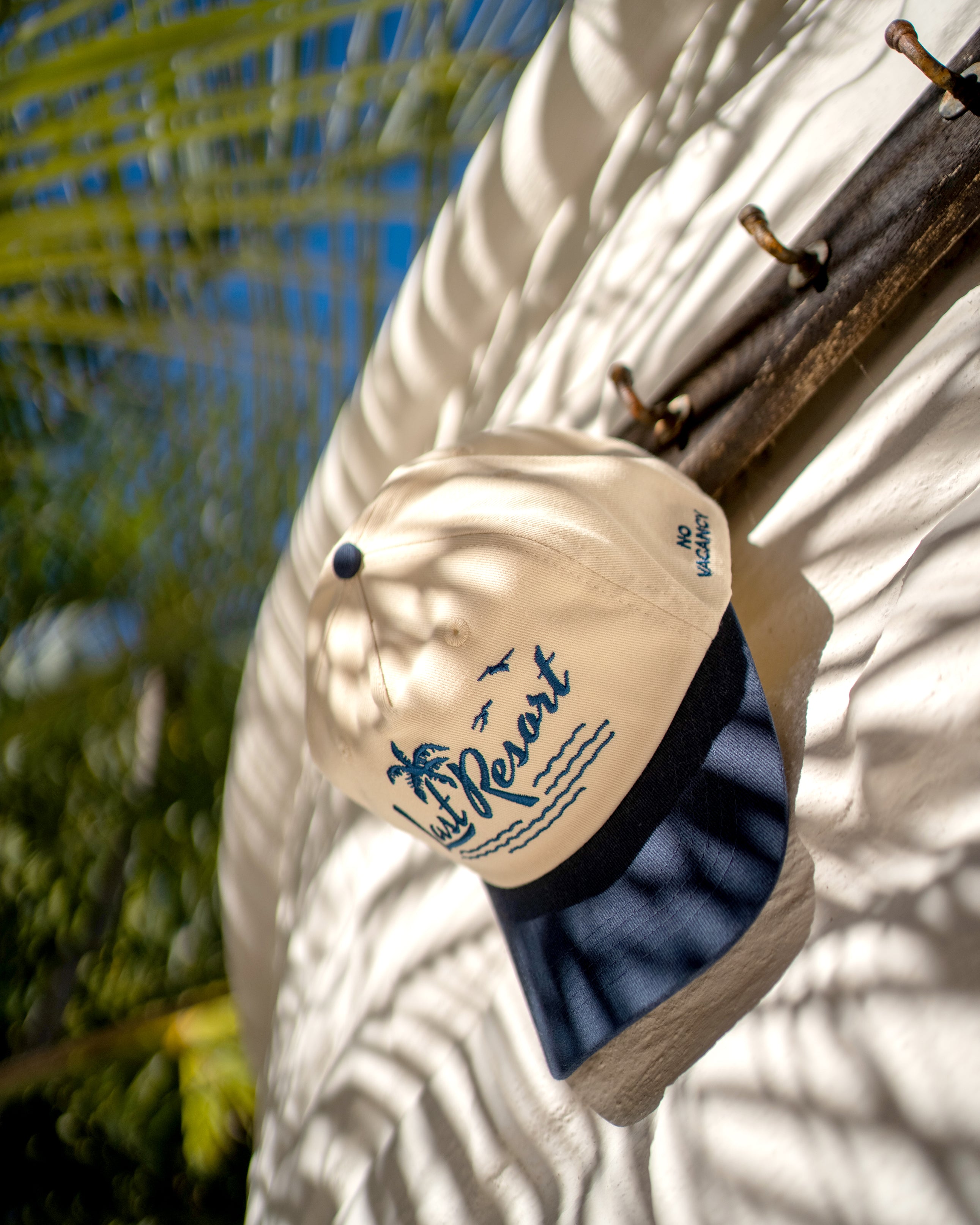 Hemlock Last Resort Baseball Hat in Navy hanging shady wall
