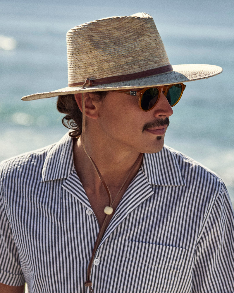 Hemlock male model wearing the Morro Fedora Straw Hat in Natural by the beach