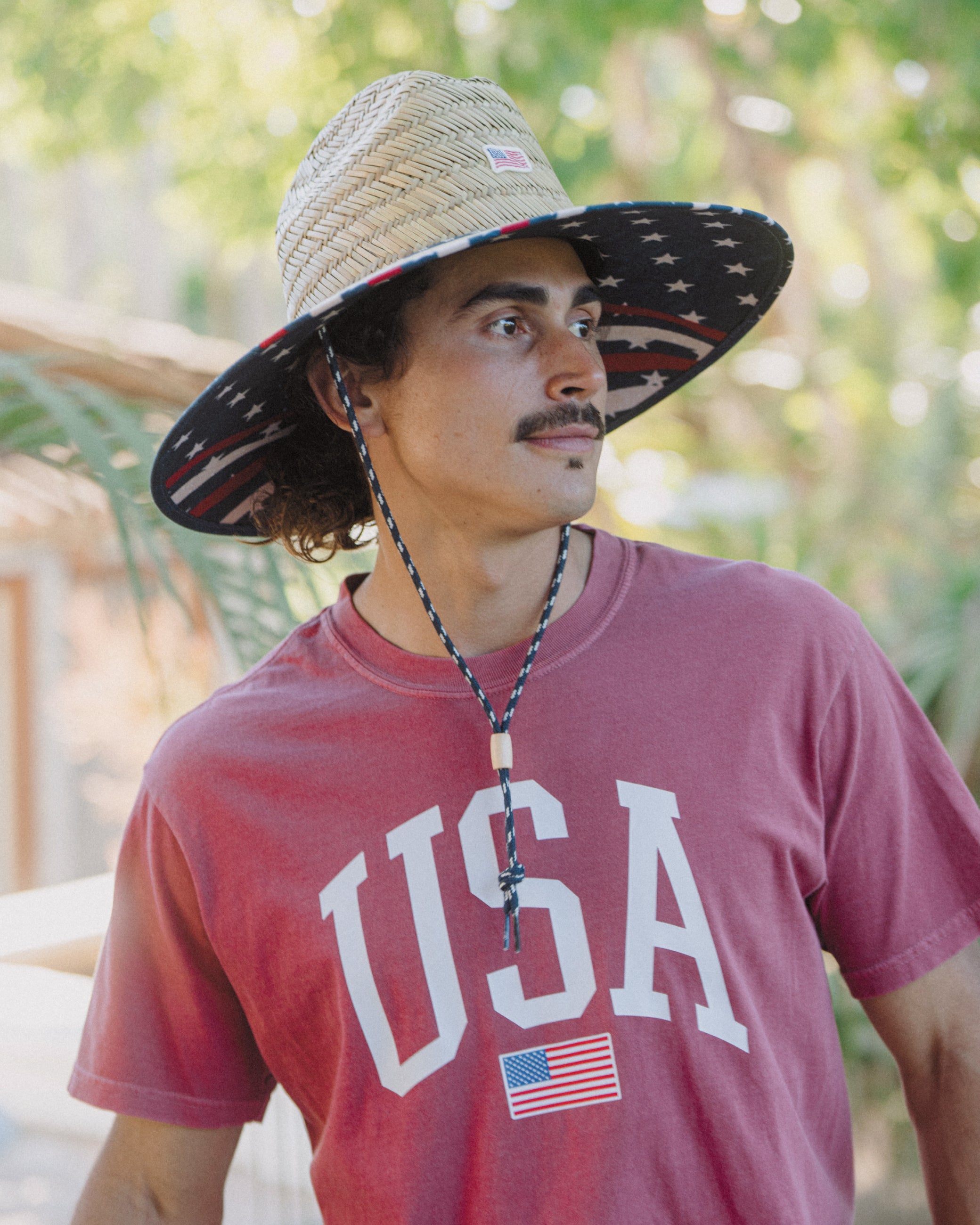 Hemlock male model wearing the UPF50+ Lifeguard Straw Hat Stars & Stripes print side profile